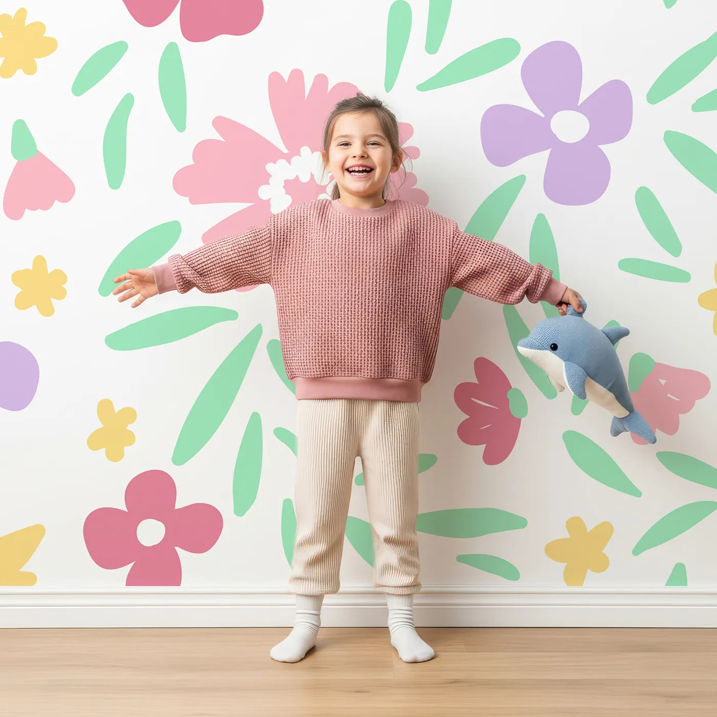 Child in front of Whimsy Tots Happy Spring Garden Wall Mural with flower, floral, pattern, colorful, spring, pink, yellow, purple in design.