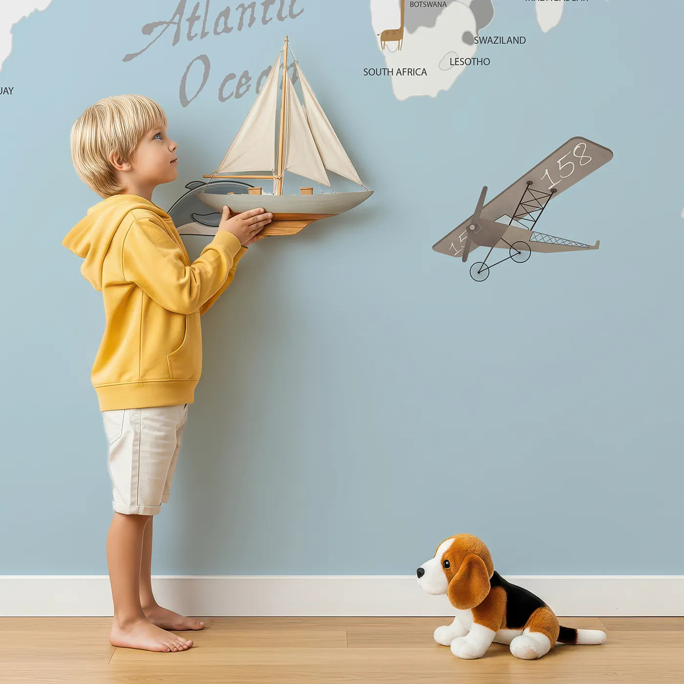 Child in front of Whimsy Tots Vintage Animal Aviator World Map Wall Mural with map, world, animal, airplane, vintage, travel, educational, cartoon in design.