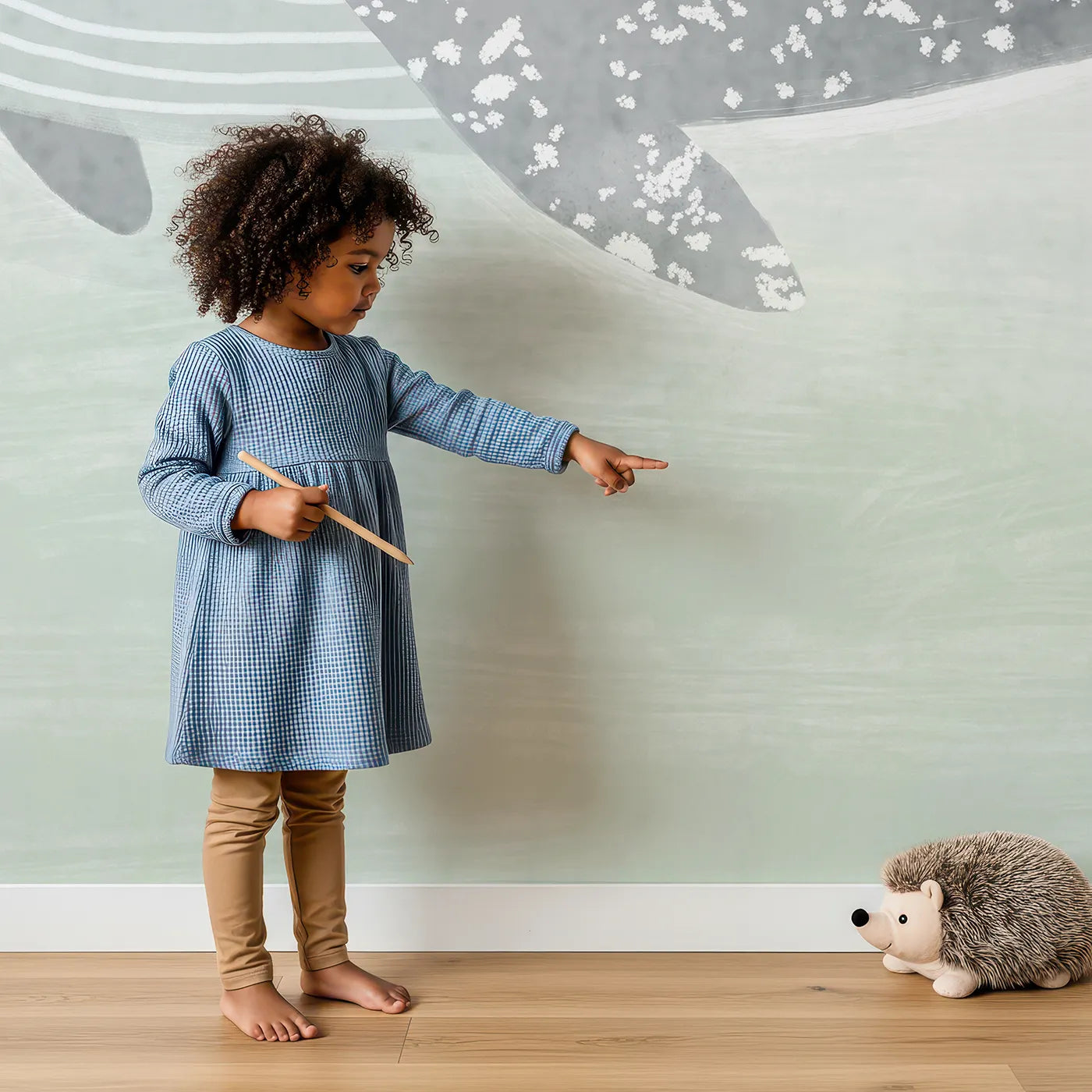 Child in front of Whimsy Tots Misty Whale Wall Mural with whale, sea, ocean, mist, sage, green, minimalist, calm in design.