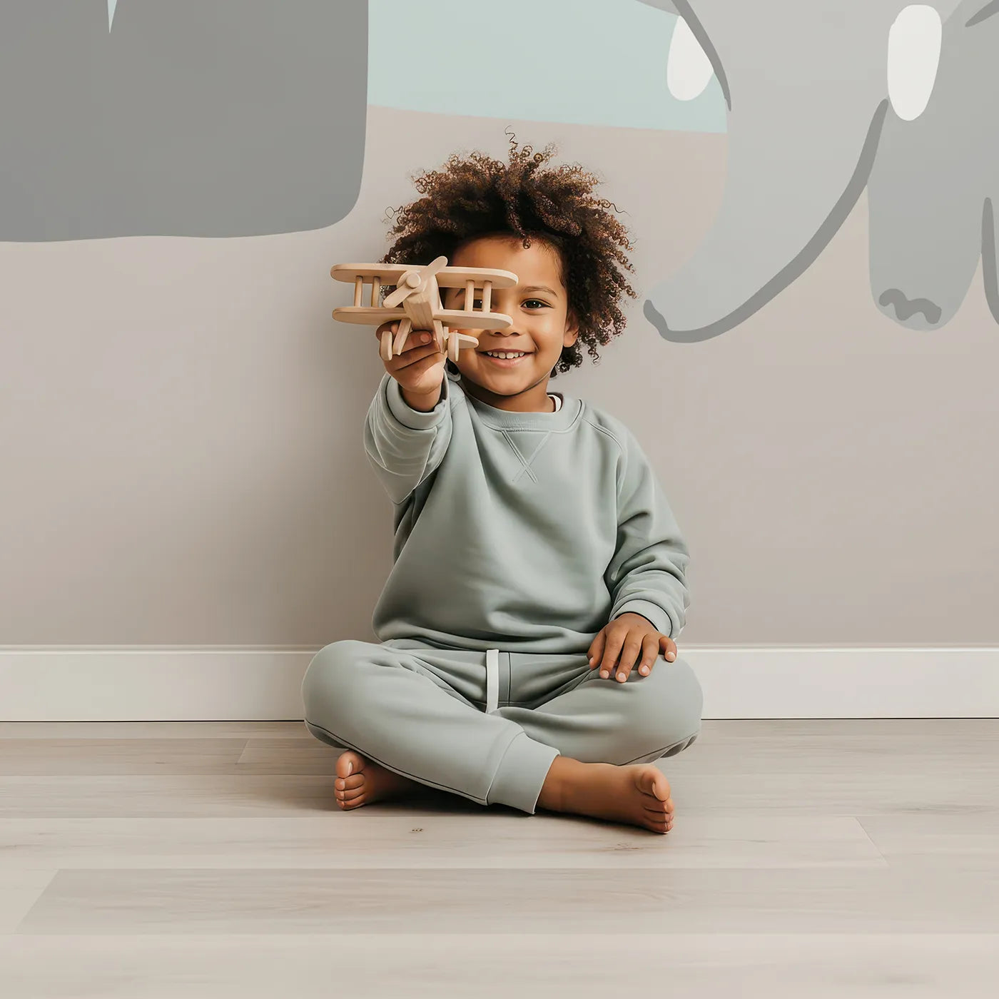 Child in front of Whimsy Tots Safari Night Wall Mural with safari, animal, night, giraffe, elephant, cute, moon, star in design.