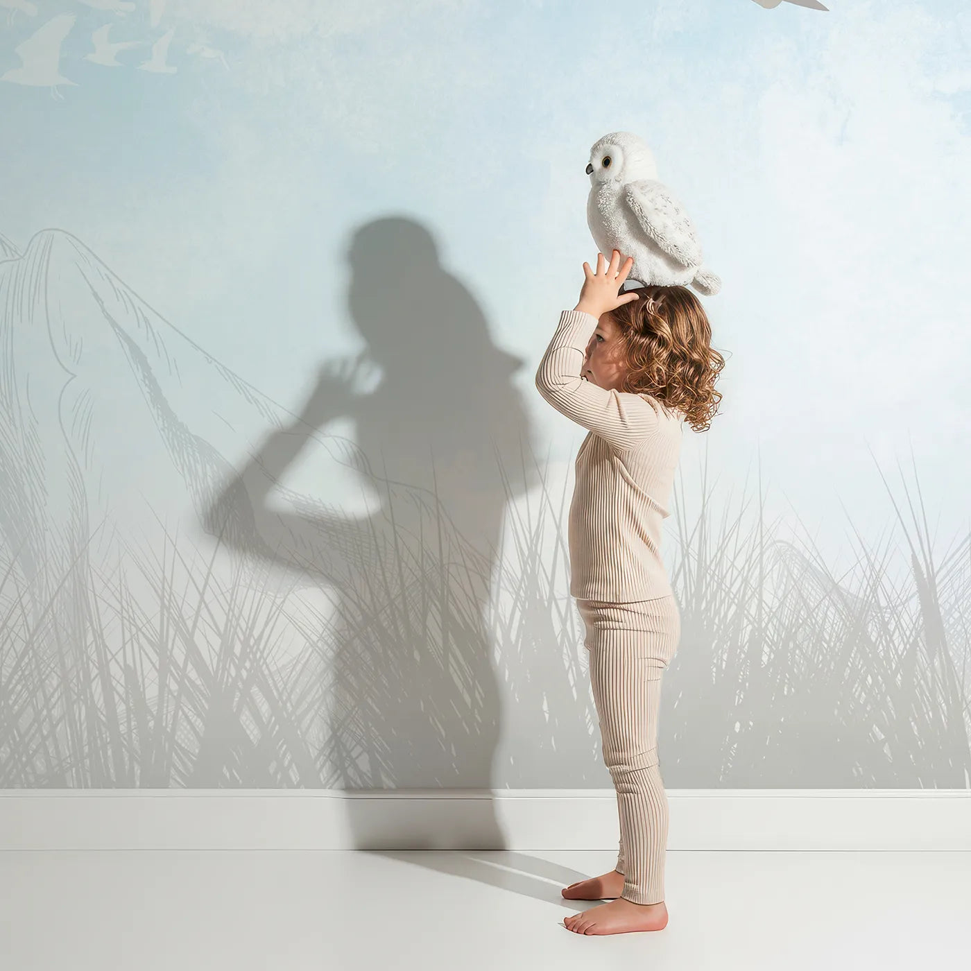Child in front of Whimsy Tots Vintage Sky Race Wall Mural with airplane, balloon, vintage, sky, cloud, retro, neutral, biplane in design.