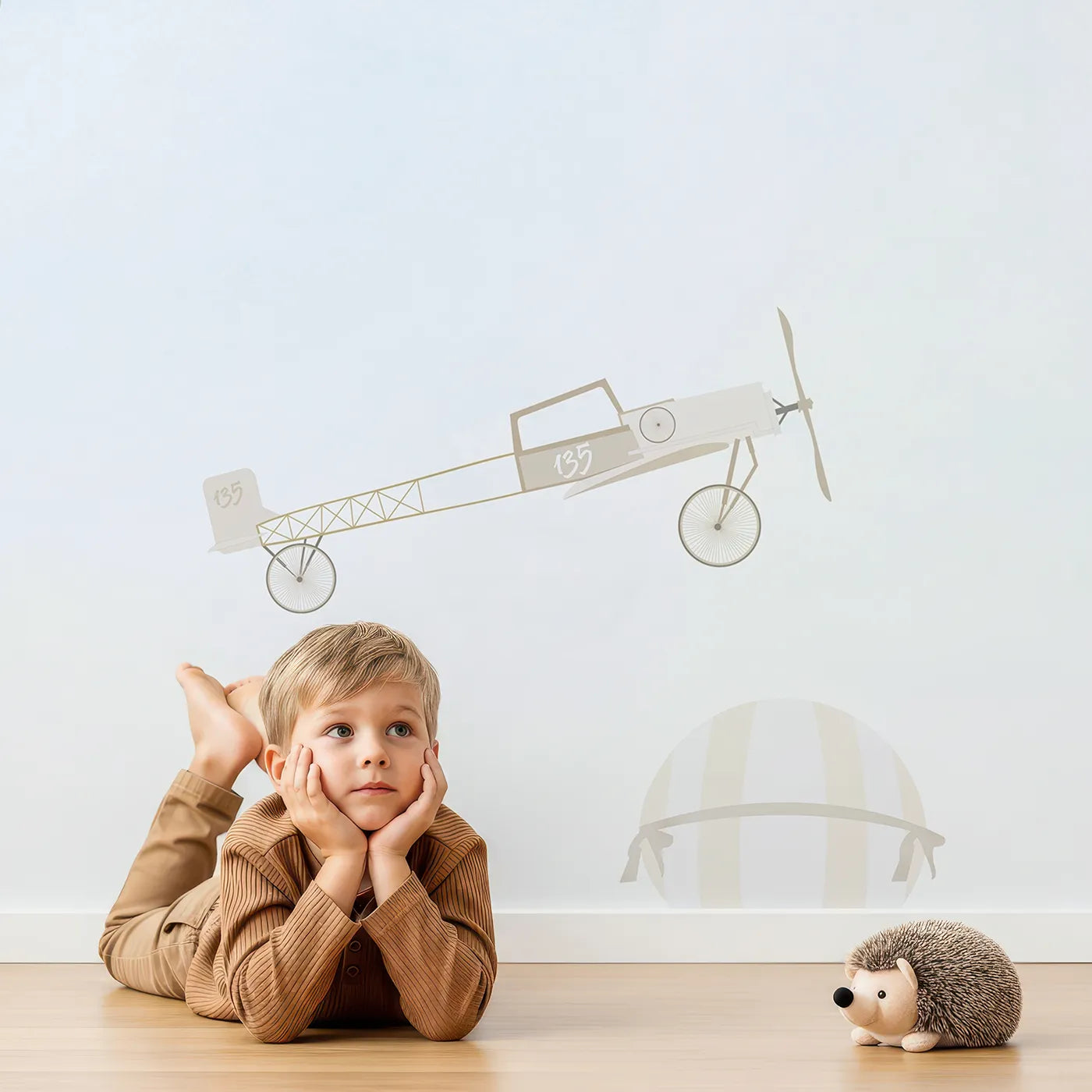 Child in front of Whimsy Tots Vintage Sky Rally Wall Mural with airplane, balloon, vintage, sky, cloud, retro, neutral, biplane in design.