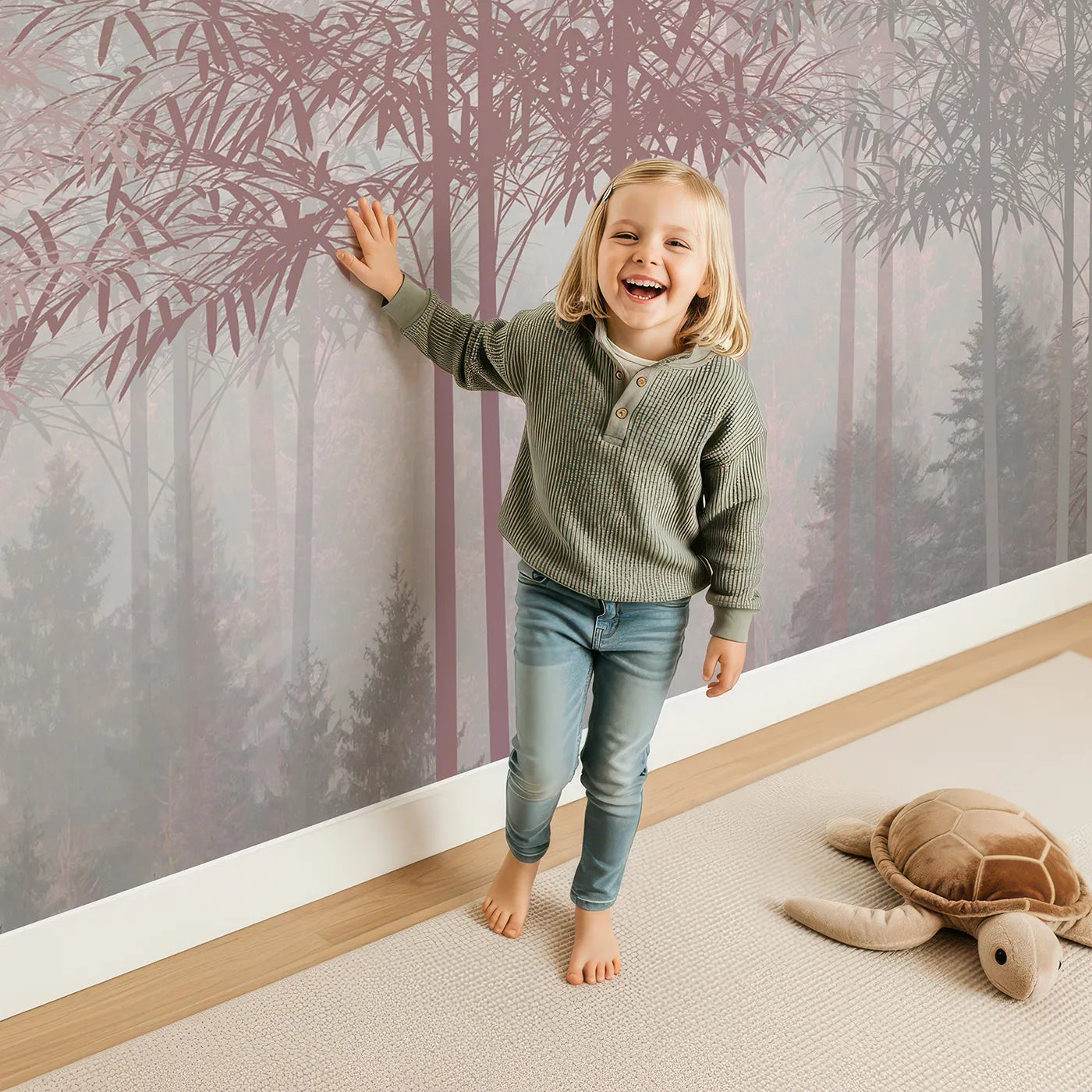 Child in front of Whimsy Tots Misty Rose Gold Forest Wall Mural with forest, mist, pink, gray, abstract, modern, tree, woods in design.