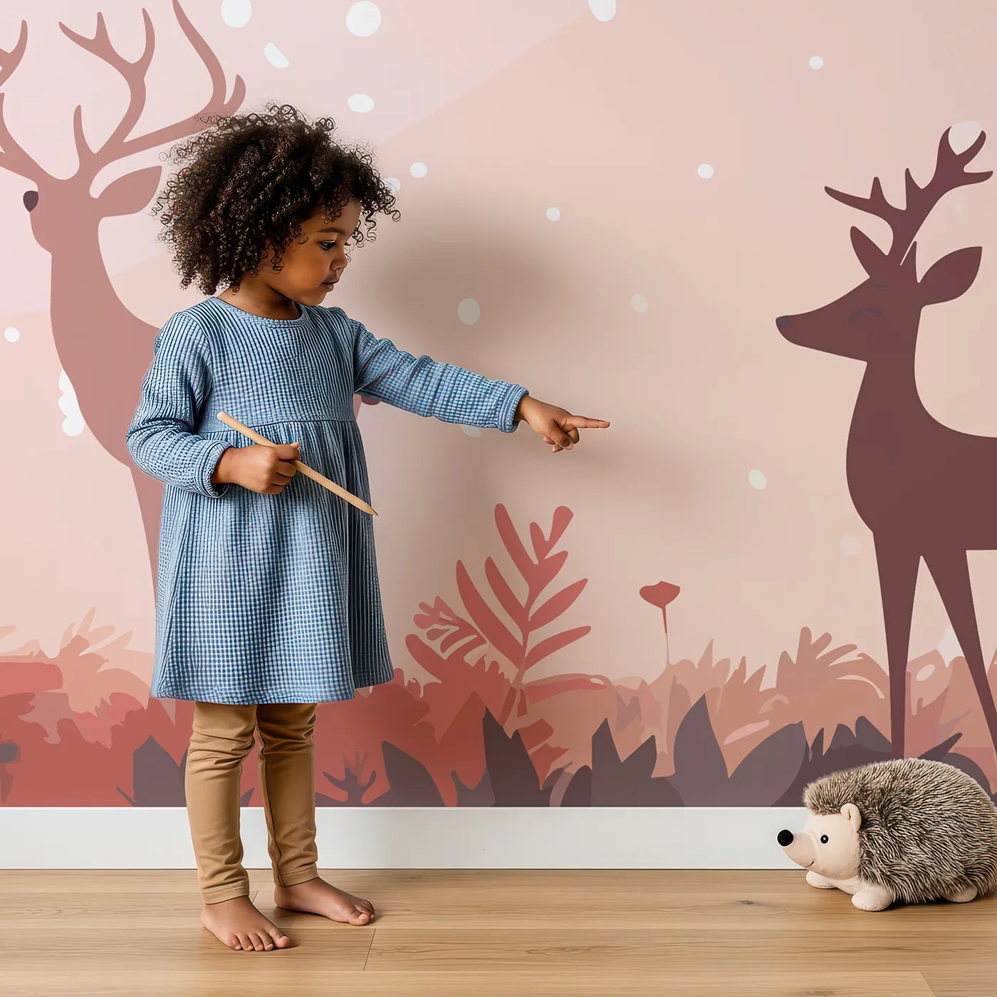 Child in front of Whimsy Tots Pink Autumn Forest Wall Mural with forest, autumn, pink, deer, tree, minimalist, modern, winter in design.