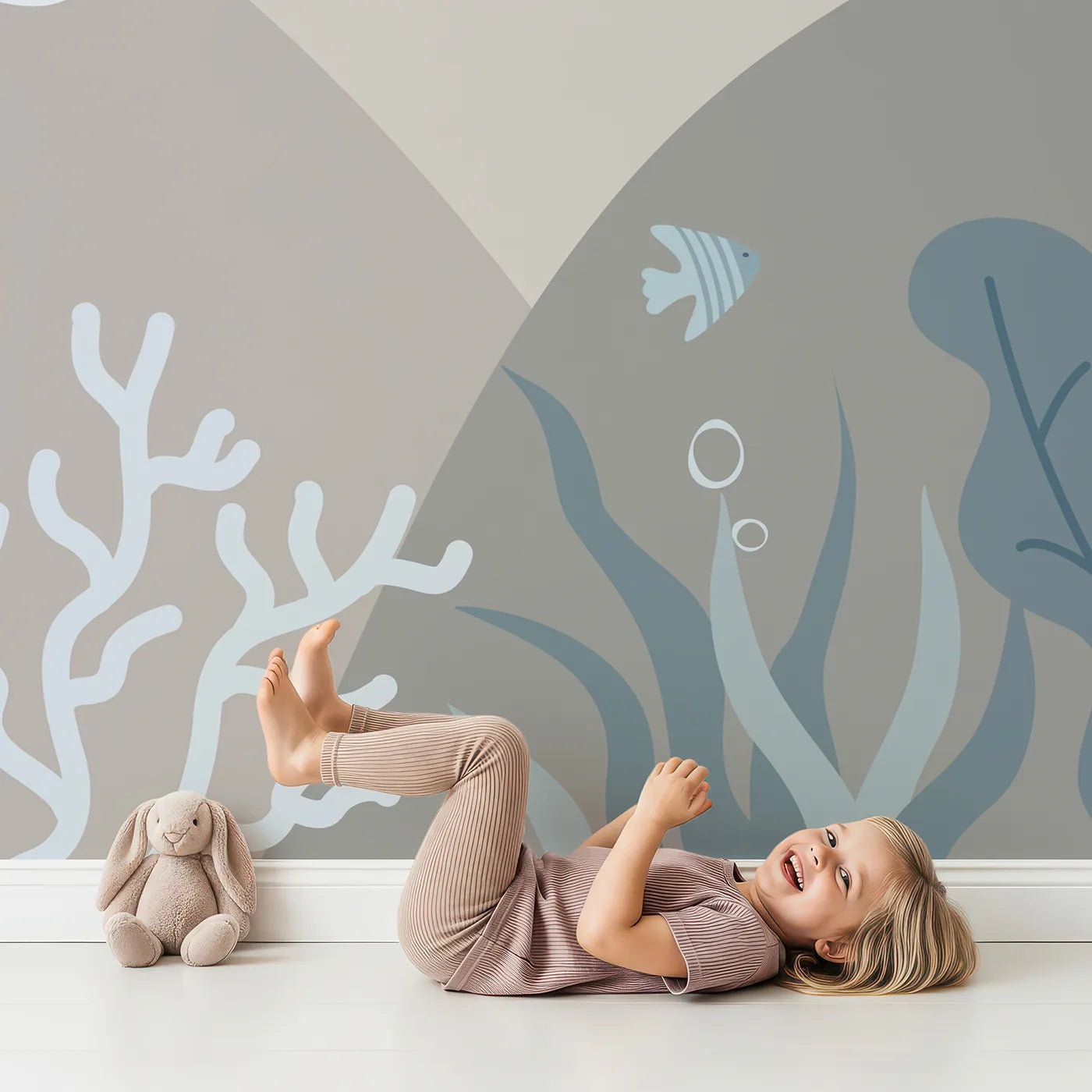 Child in front of Whimsy Tots Neutral Tone Coral Reef Wall Mural with ocean, sea, abstract, minimalist, blue, beige, underwater, coral in design.