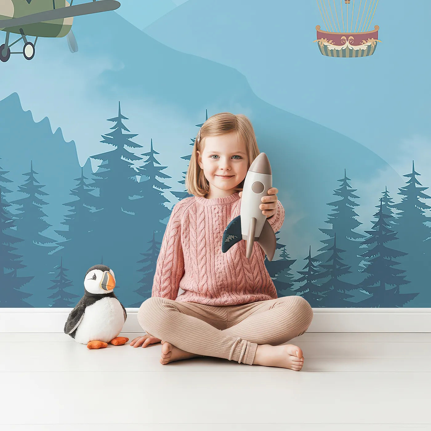 Child in front of Whimsy Tots Whimsical Sky Rally Wall Mural with airplane, balloon, vintage, forest, mountain, colorful, whimsical, cute in design.