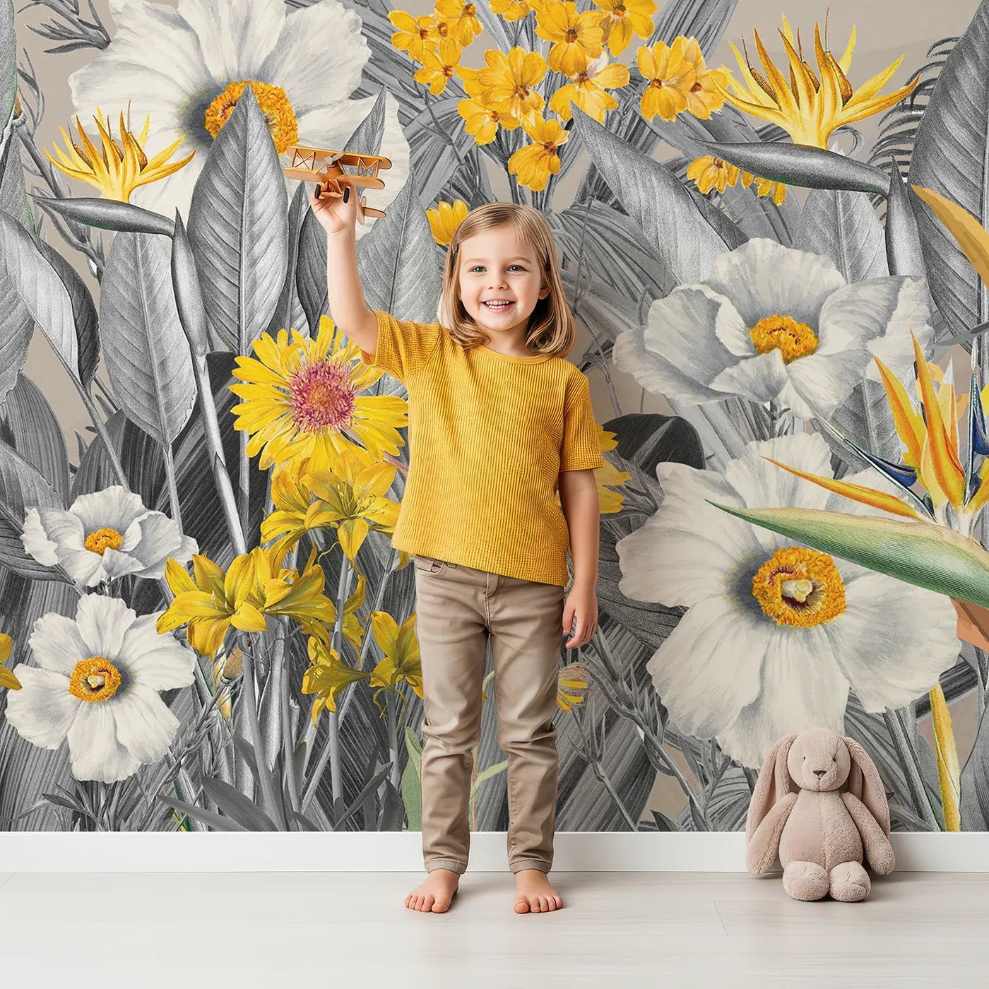 Child in front of Whimsy Tots Yellow and Gray Tropical Garden Wall Mural with jungle, tropical, gray, yellow, flower, leaf, modern, monochrome in design.