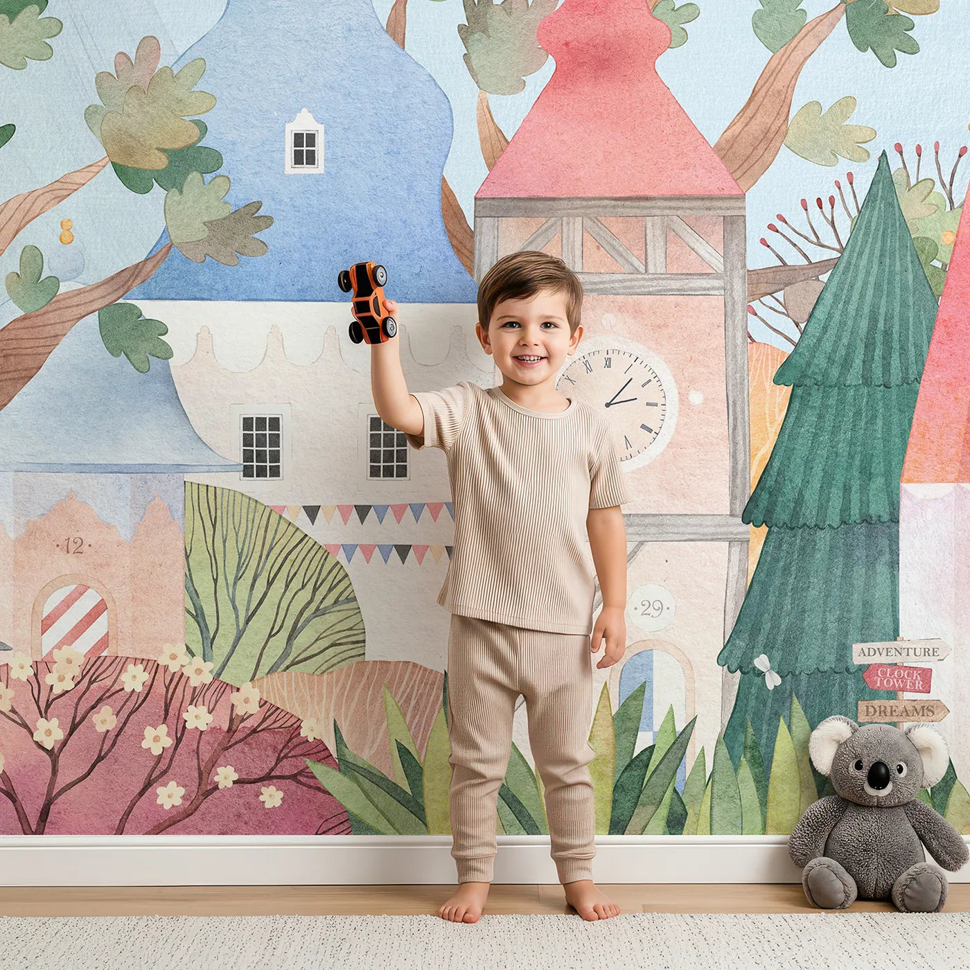Child in front of Whimsy Tots Whimsical Village Wall Mural with castle, village, whimsical, watercolor, adventure, tree, fantasy, cute in design.