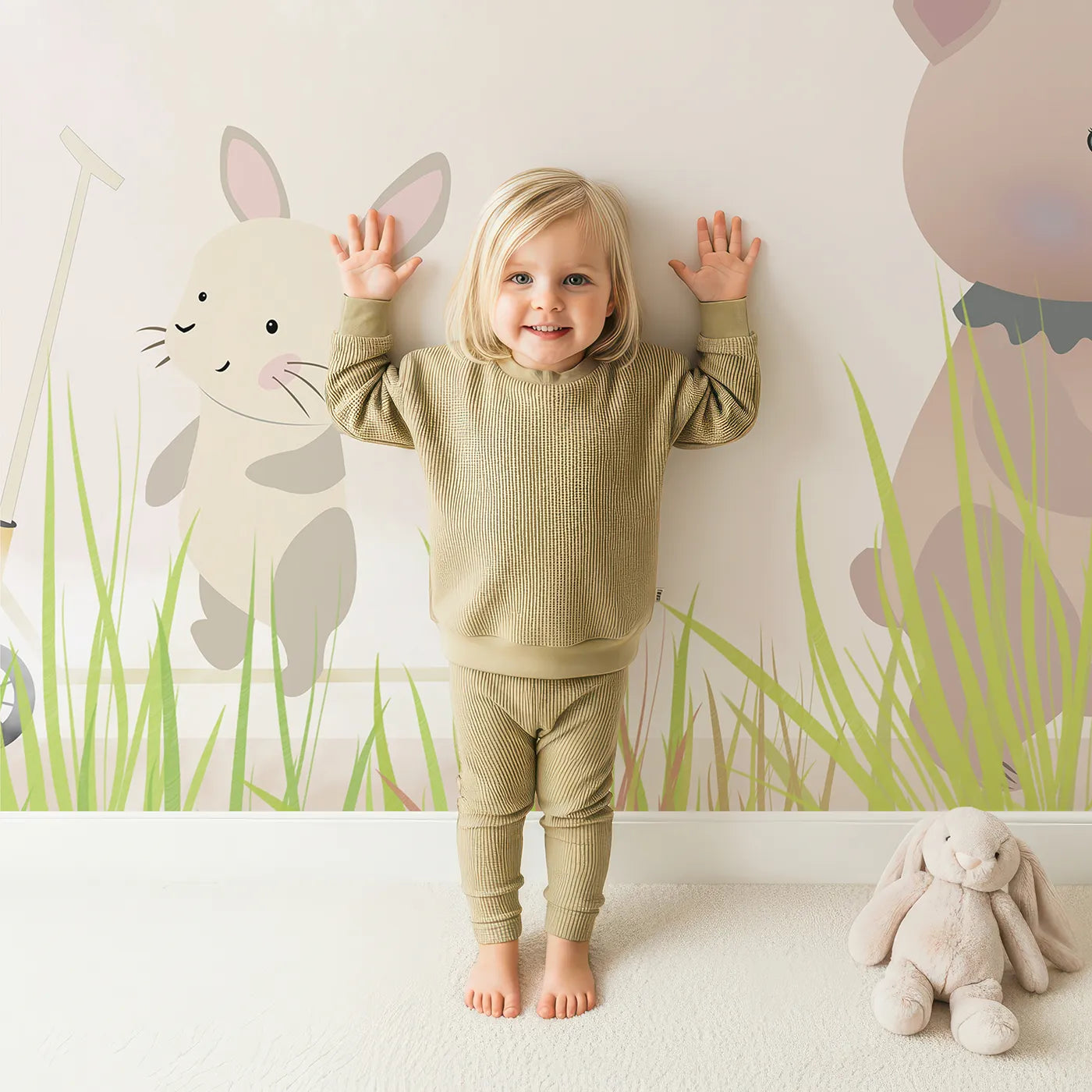 Child in front of Whimsy Tots Safari Moon Wall Mural with animal, safari, moon, cute, sleep, beige, nursery, balloon in design.