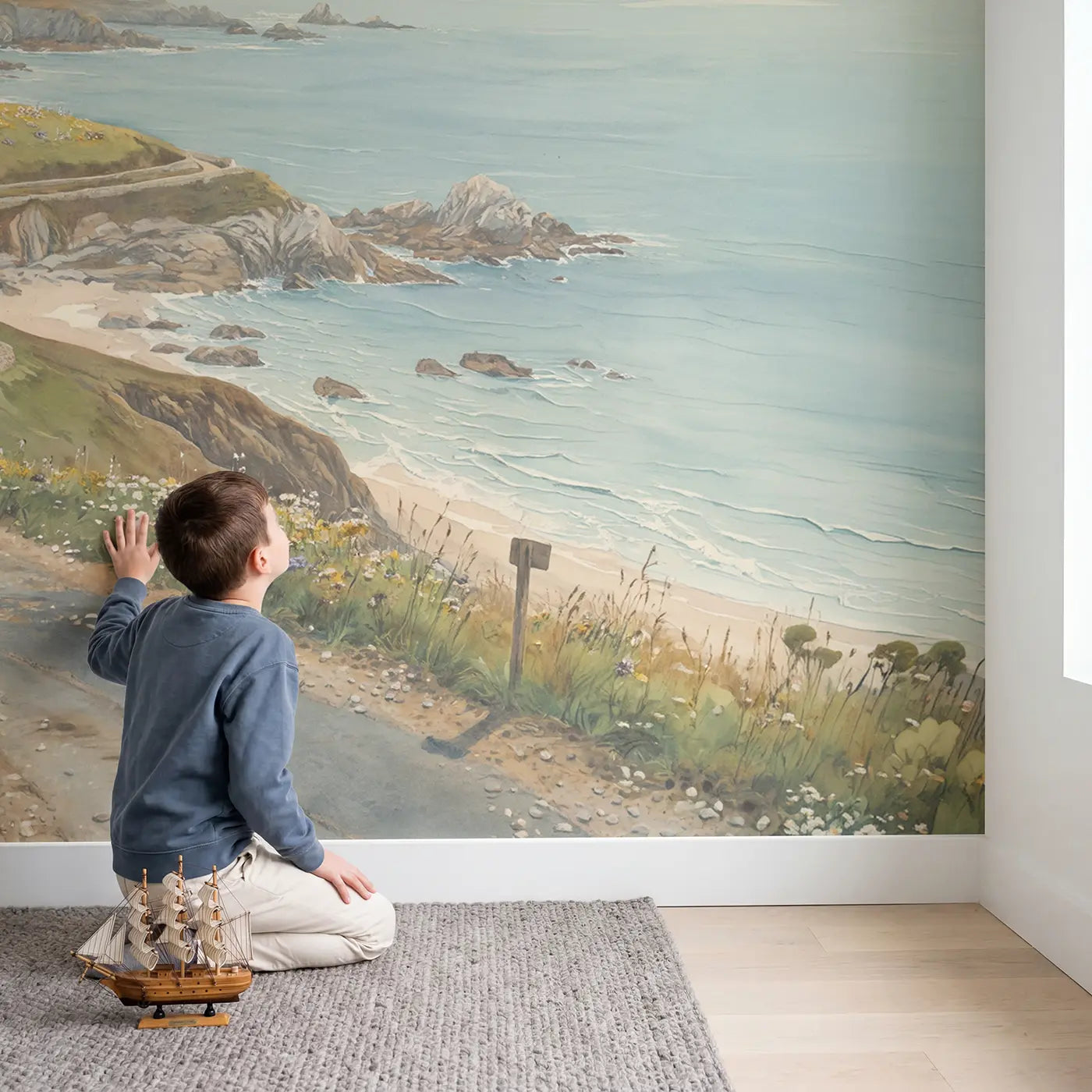 Child in nursery with Coastal Clifftop Road Wallpaper Mural by Whimsy Tots