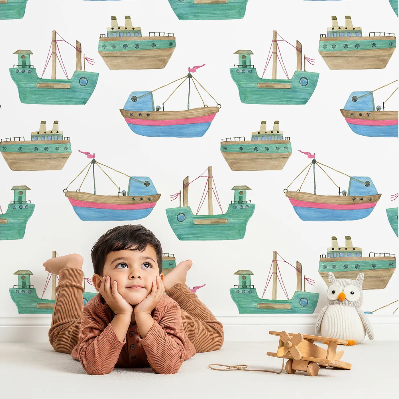 Lovely child standing in front of Whimsy Tots Watercolor Fishing Boats Wallpaper with boat, ship, sea, ocean, watercolor in design.