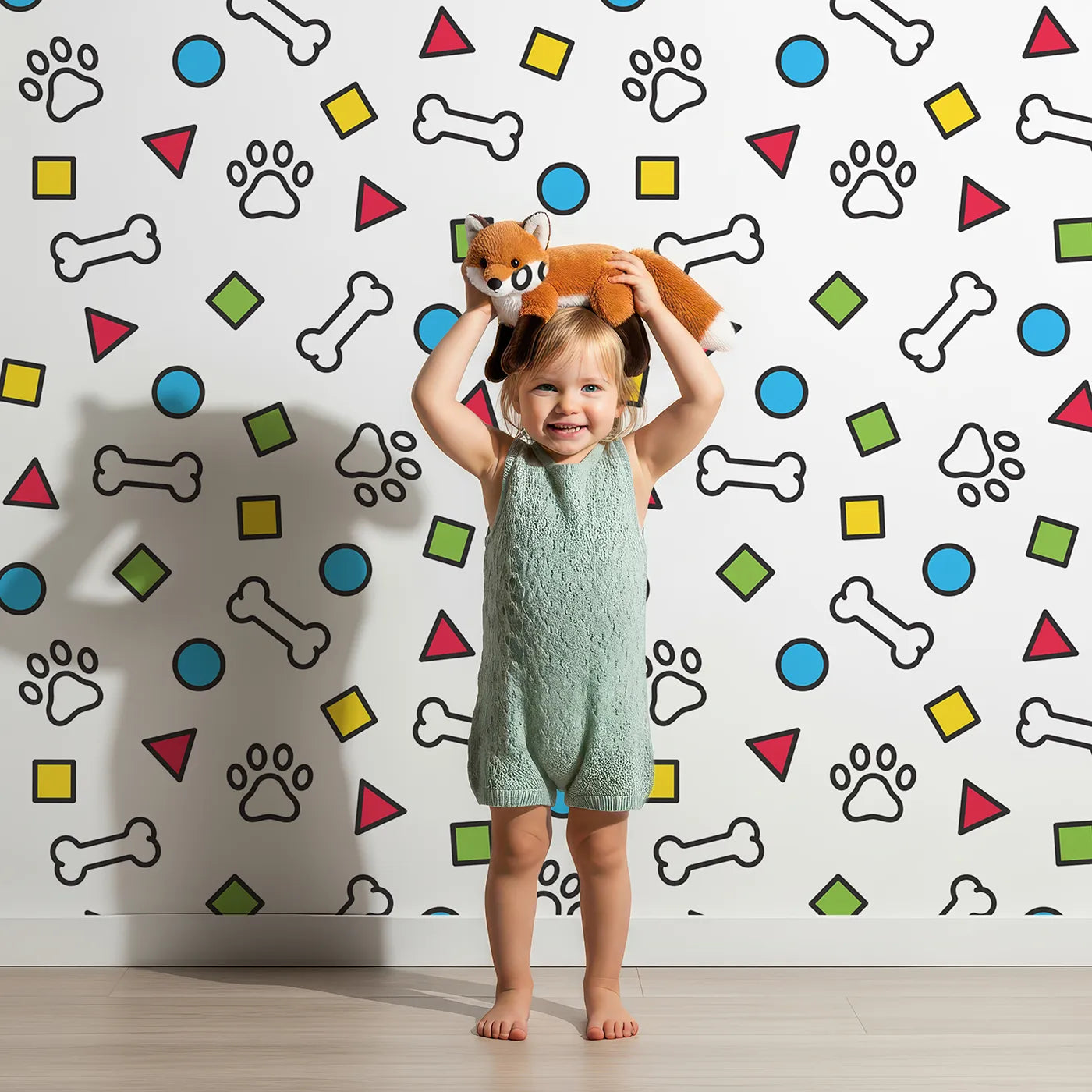 Lovely child standing in front of Whimsy Tots Playful Paws and Shapes Wallpaper with paw print, bone, dog, shape, geometric in design.