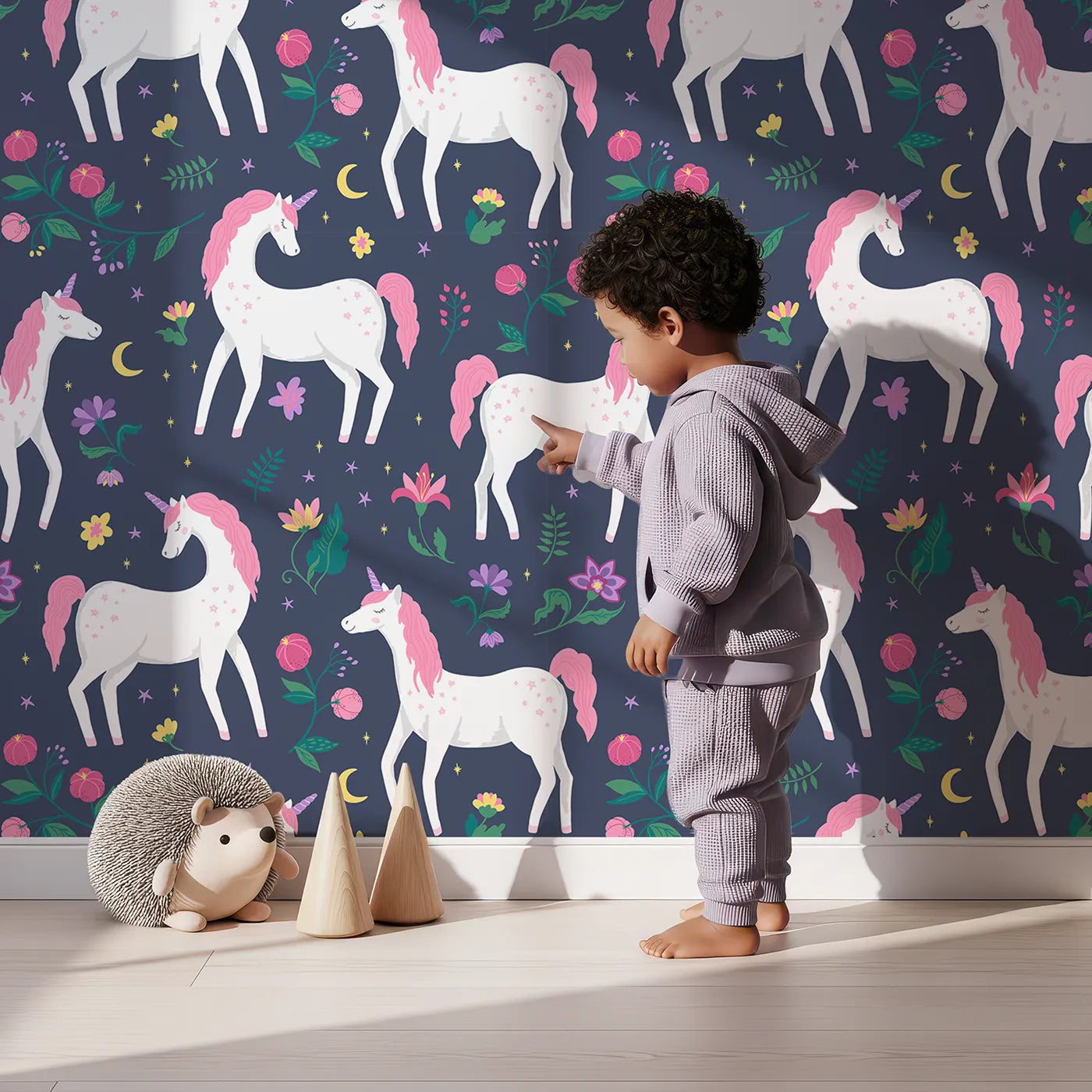 Lovely child standing in front of Whimsy Tots Midnight Unicorn Garden Wallpaper with unicorn, flower, moon, star, floral in design.
