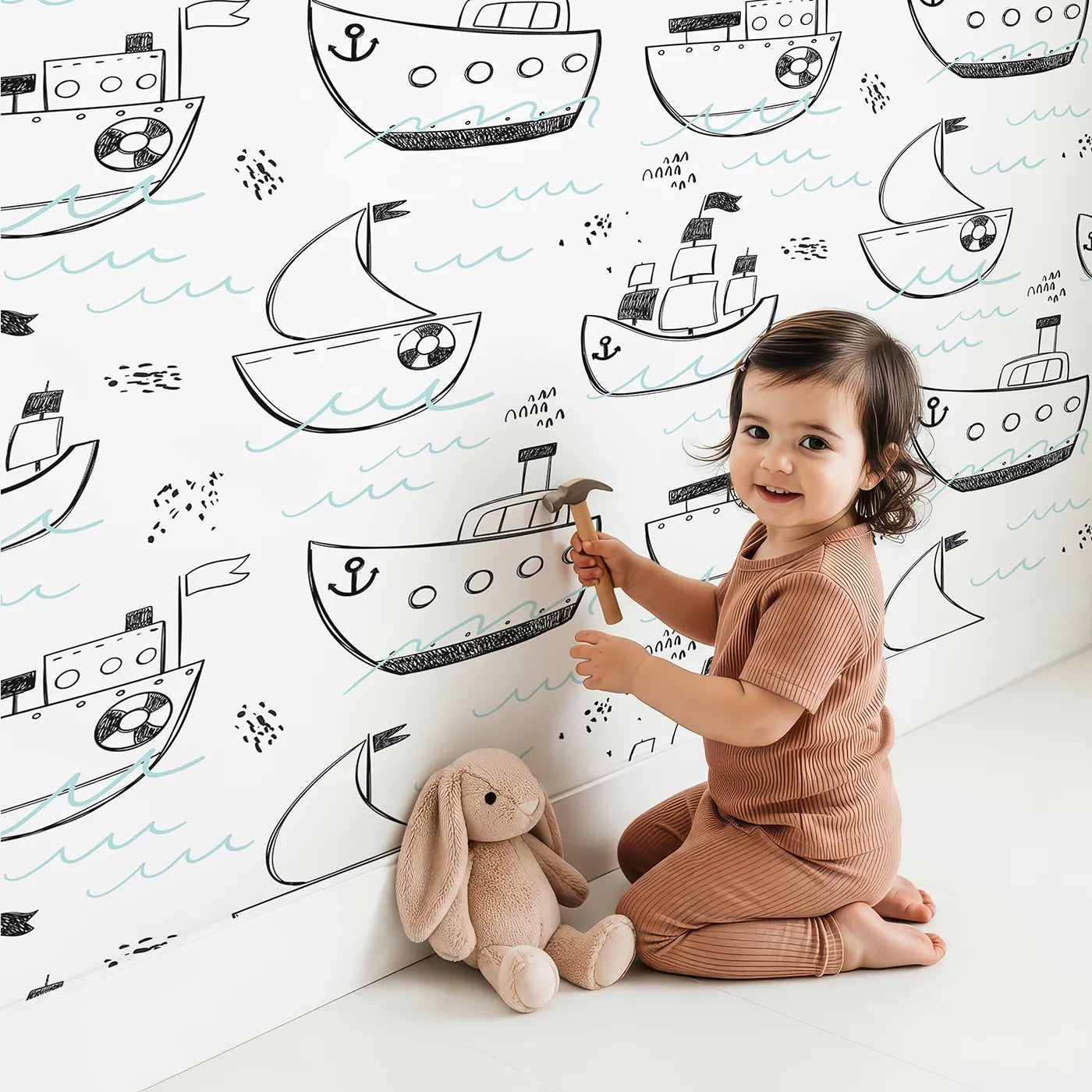 Lovely child standing in front of Whimsy Tots Maritime Doodle Wallpaper with ship, boat, sea, ocean, doodle in design.