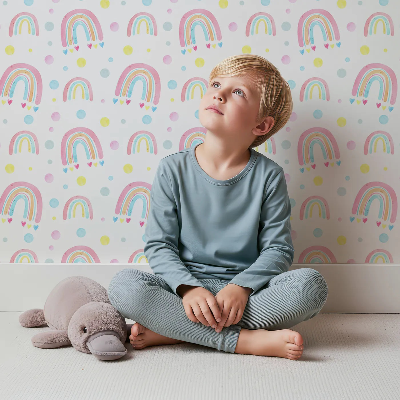 Lovely child standing in front of Whimsy Tots Watercolor Rainbow Dots Wallpaper with rainbow, dot, heart, watercolor, pastel in design.