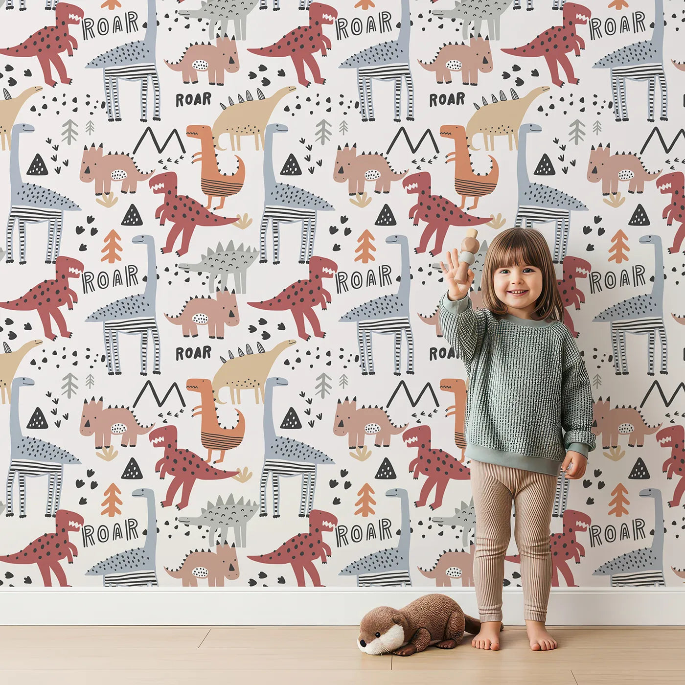 Lovely child standing in front of Whimsy Tots Scandi Dino Roar Wallpaper with dinosaur, roar, scandinavian, modern, t-rex in design.