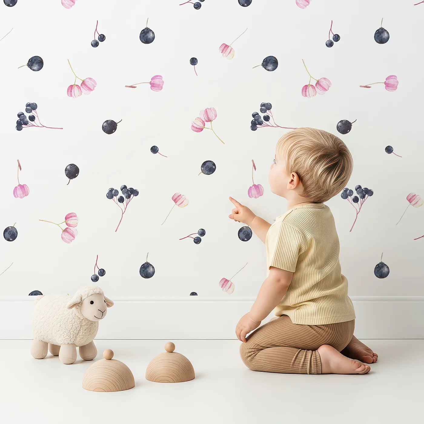 Lovely child standing in front of Whimsy Tots Watercolor Berries and Blooms Wallpaper with berry, flower, watercolor, minimalist, botanical in design.