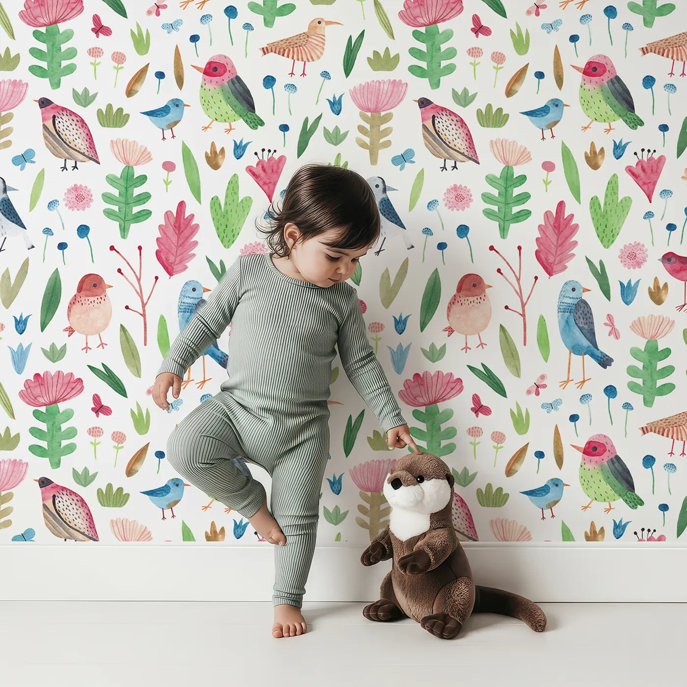 Lovely child standing in front of Whimsy Tots Watercolor Bird and Bloom Wallpaper with bird, flower, butterfly, watercolor, botanical in design.