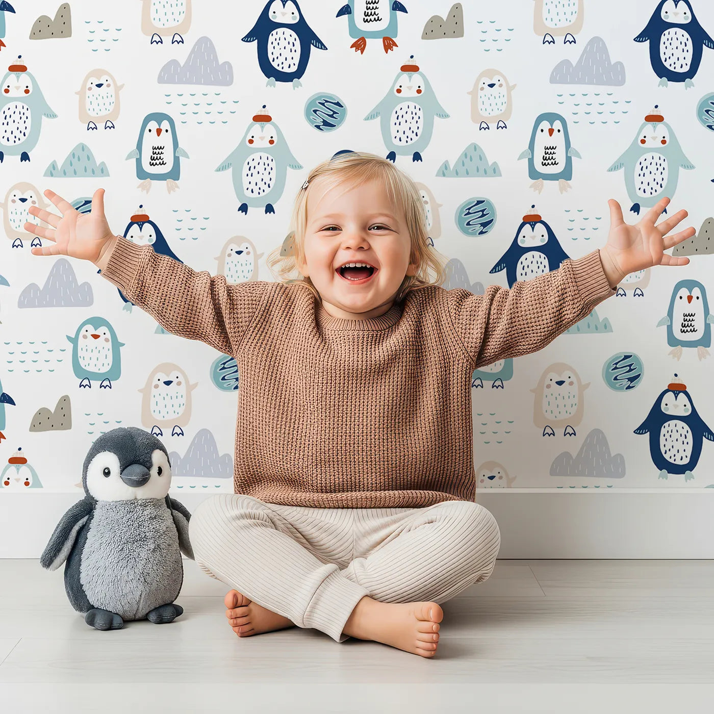 Lovely child standing in front of Whimsy Tots Playful Penguin Pals Wallpaper with penguin, arctic, snow, winter, cute in design.