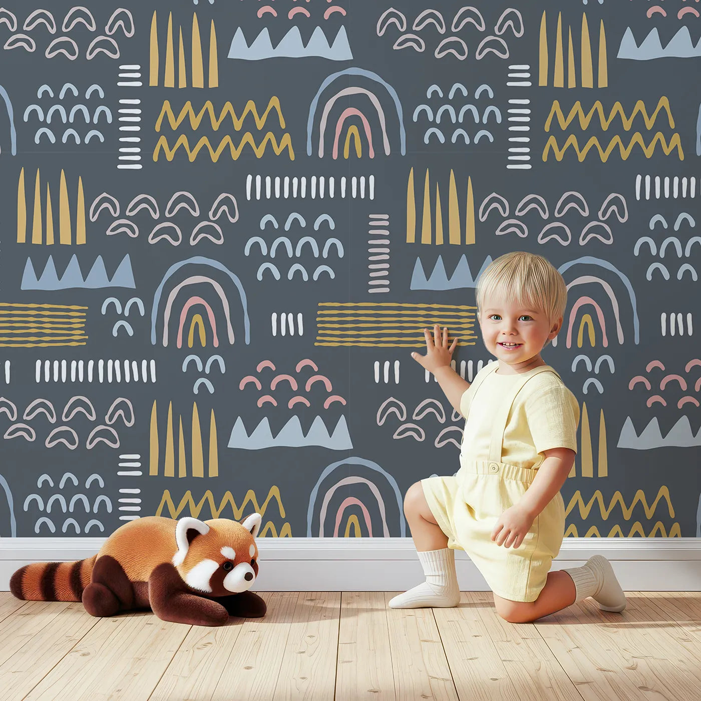 Lovely child standing in front of Whimsy Tots Abstract Rainbow Shapes Wallpaper in Blue with abstract, rainbow, geometric, modern, shape in design.