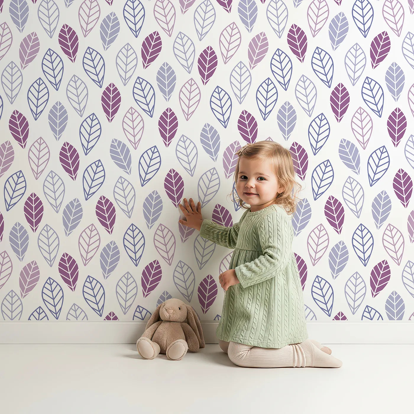Lovely child standing in front of Whimsy Tots Geometric Leaf Pattern Wallpaper in Purple with leaf, geometric, modern, purple, botanical in design.