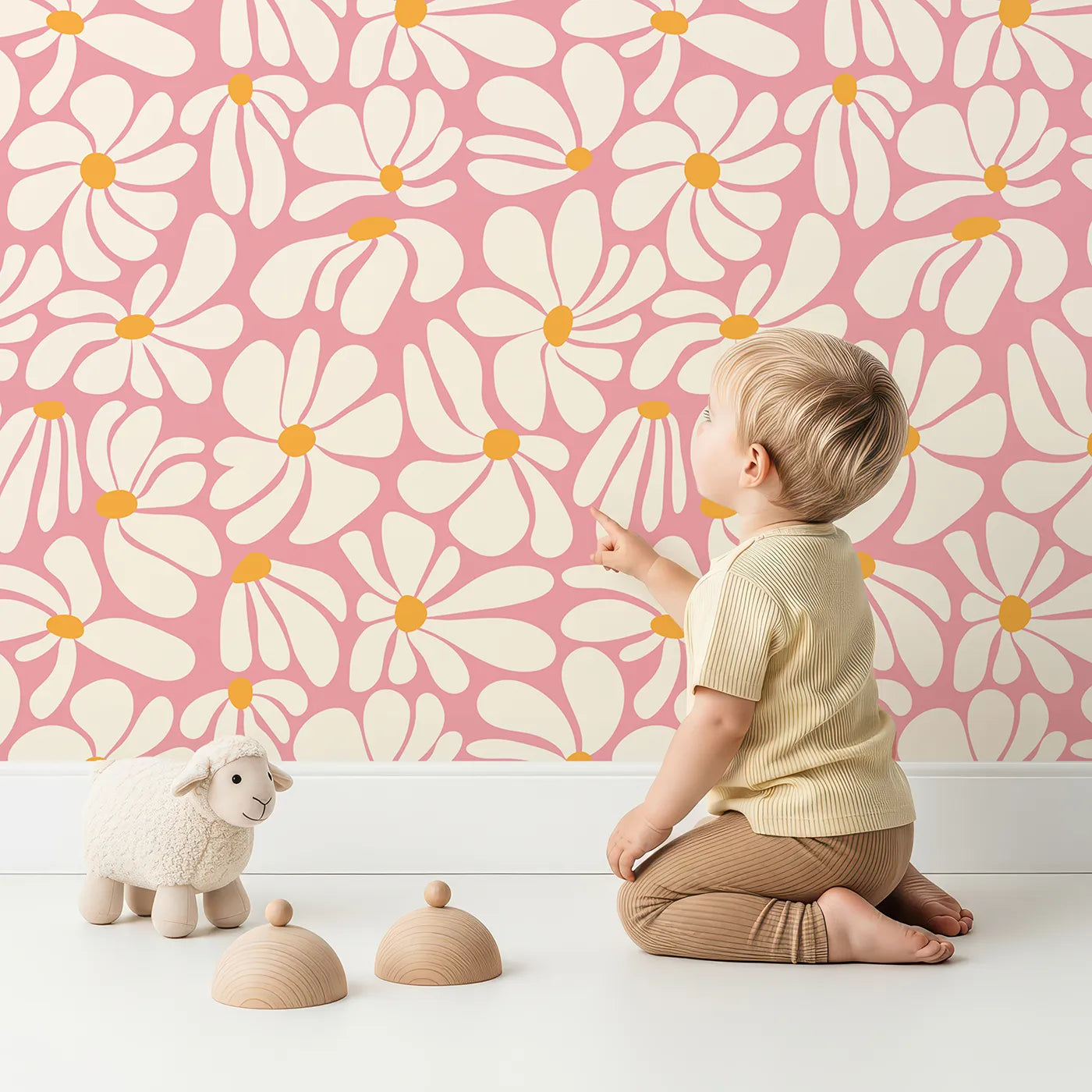 Lovely child standing in front of Whimsy Tots Groovy Daisy Wallpaper in Pink with daisy, flower, retro, 70s, pink in design.