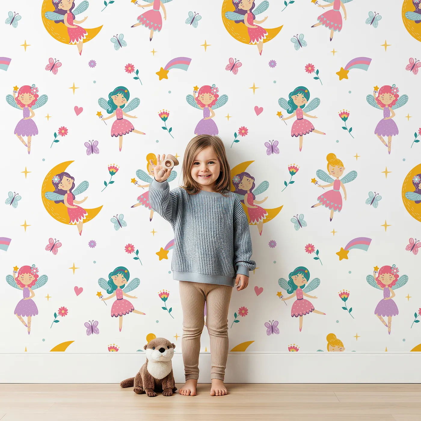 Lovely child standing in front of Whimsy Tots Moonbeam Fairy Garden Wallpaper with fairy, moon, star, butterfly, magic in design.