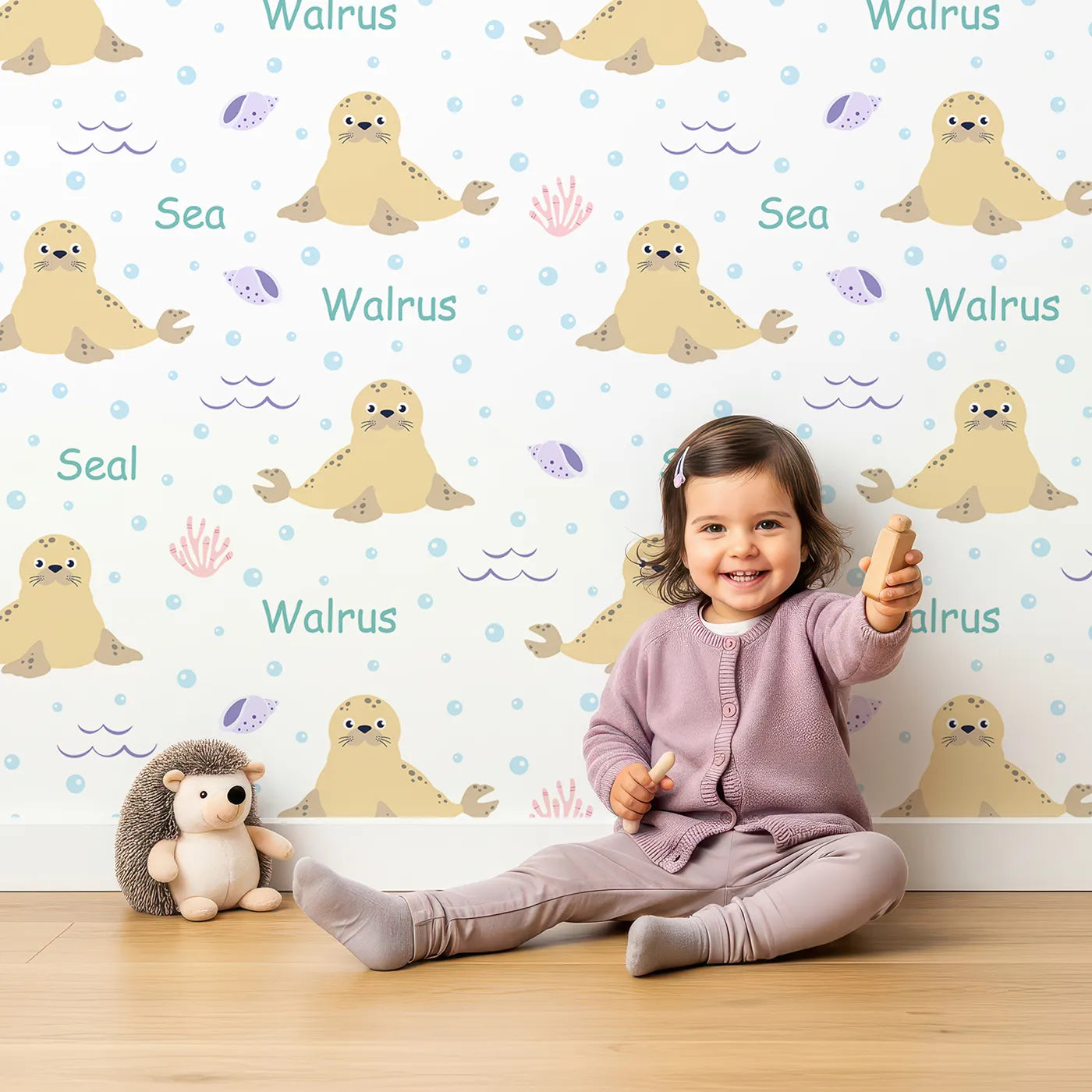 Lovely child standing in front of Whimsy Tots Arctic Seal and Walrus Wallpaper with seal, walrus, ocean, sea, cute in design.