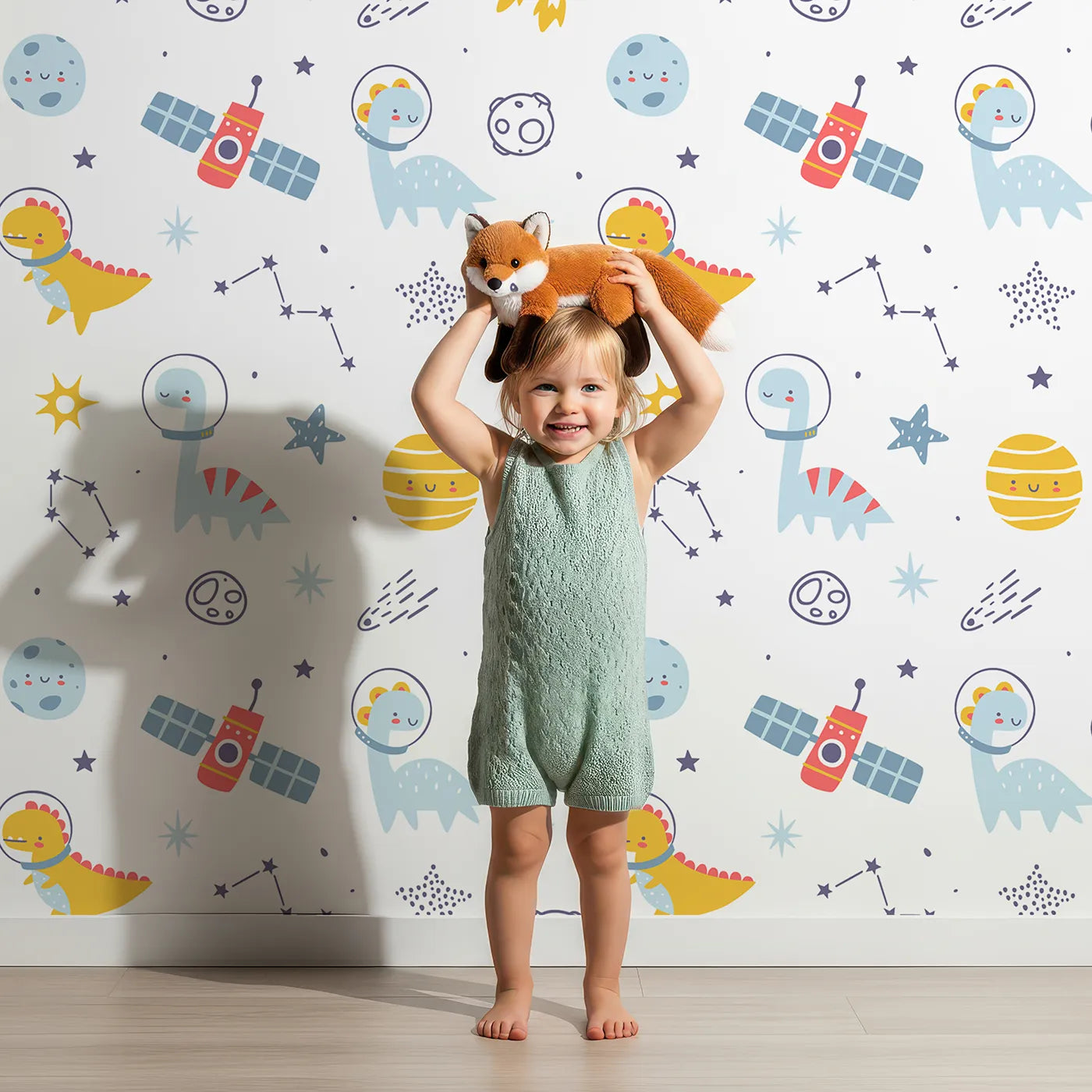 Lovely child standing in front of Whimsy Tots Dino Space Explorer Wallpaper with dinosaur, space, rocket, planet, cute in design.