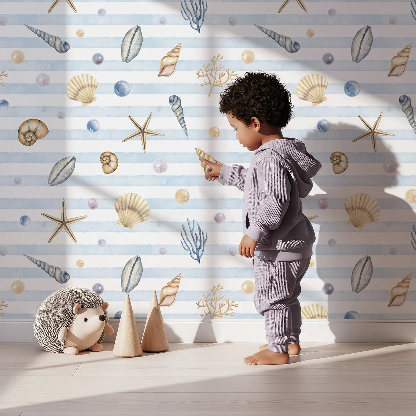 Lovely child standing in front of Whimsy Tots Watercolor Seashell Stripes Wallpaper with shell, starfish, pearl, watercolor, stripe in design.