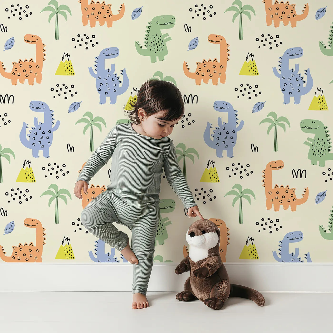 Lovely child standing in front of Whimsy Tots Playful Dino Volcano Land Wallpaper with dinosaur, volcano, palm tree, cute, cartoon in design.