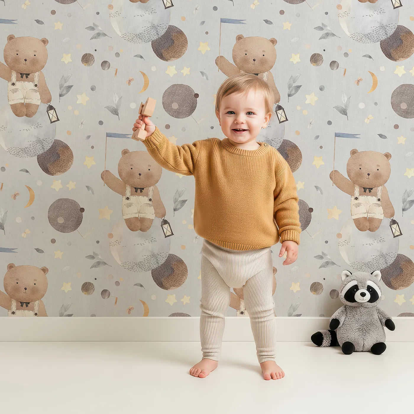 Lovely child standing in front of Whimsy Tots Watercolor Bear in the Stars Wallpaper with bear, space, planet, star, watercolor in design.