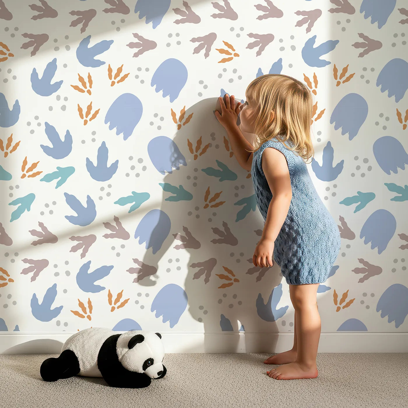 Lovely child standing in front of Whimsy Tots Dinosaur Footprints Wallpaper with dinosaur, footprint, track, fossil, prehistoric in design.