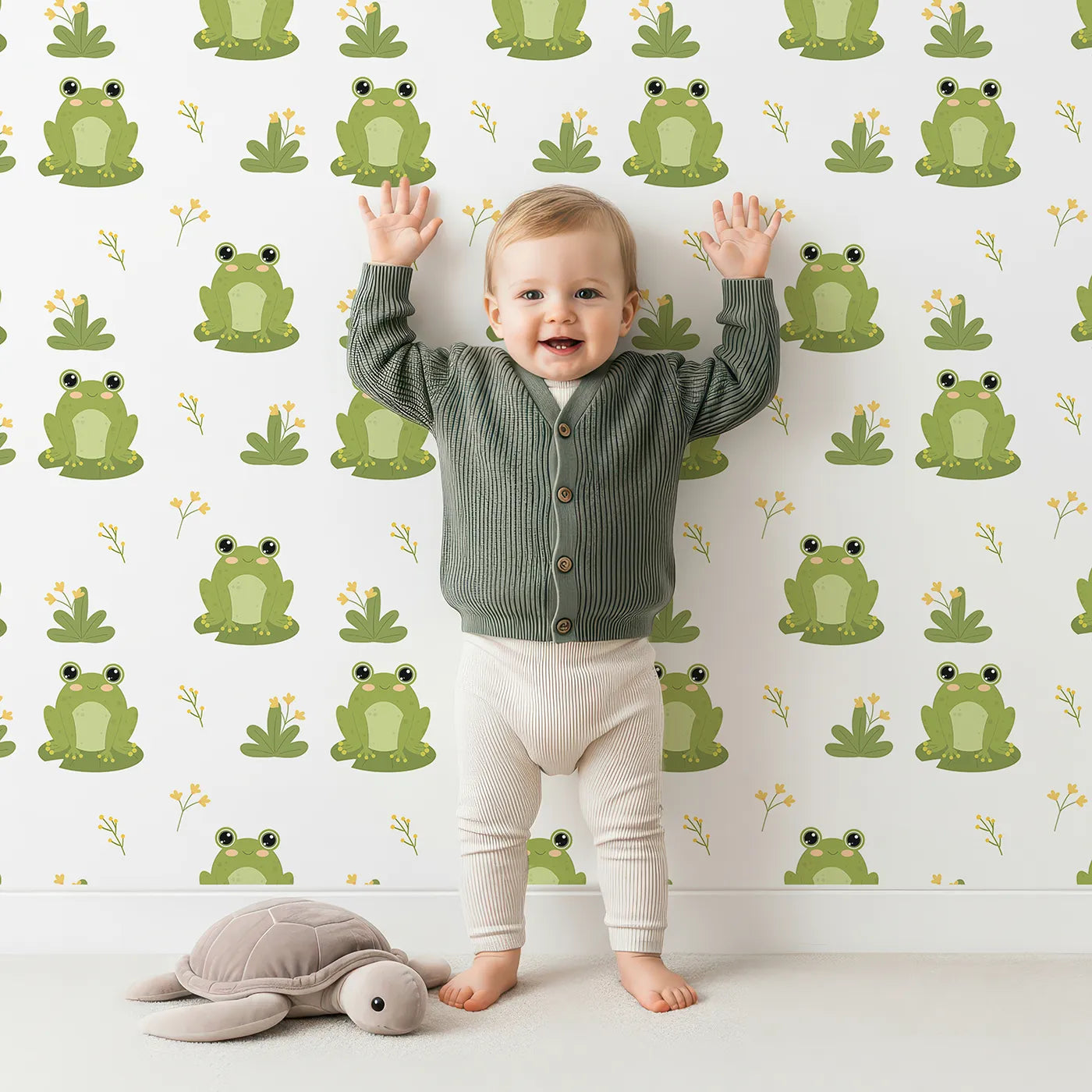 Lovely child standing in front of Whimsy Tots Happy Frog Pond Wallpaper with frog, pond, flower, cute, green in design.