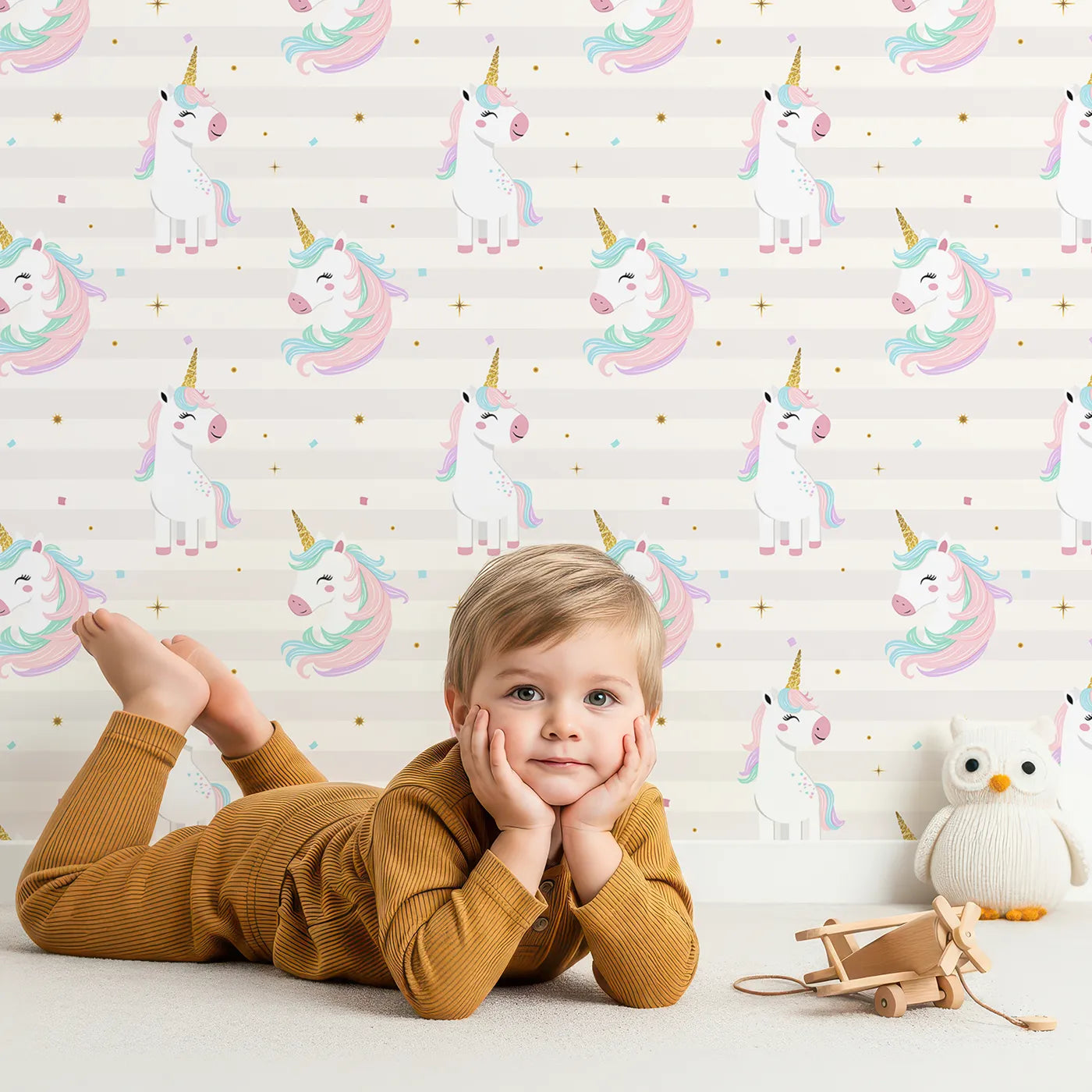 Lovely child standing in front of Whimsy Tots Glitter Unicorn Party Wallpaper in Purple with unicorn, glitter, purple, rainbow, confetti in design.