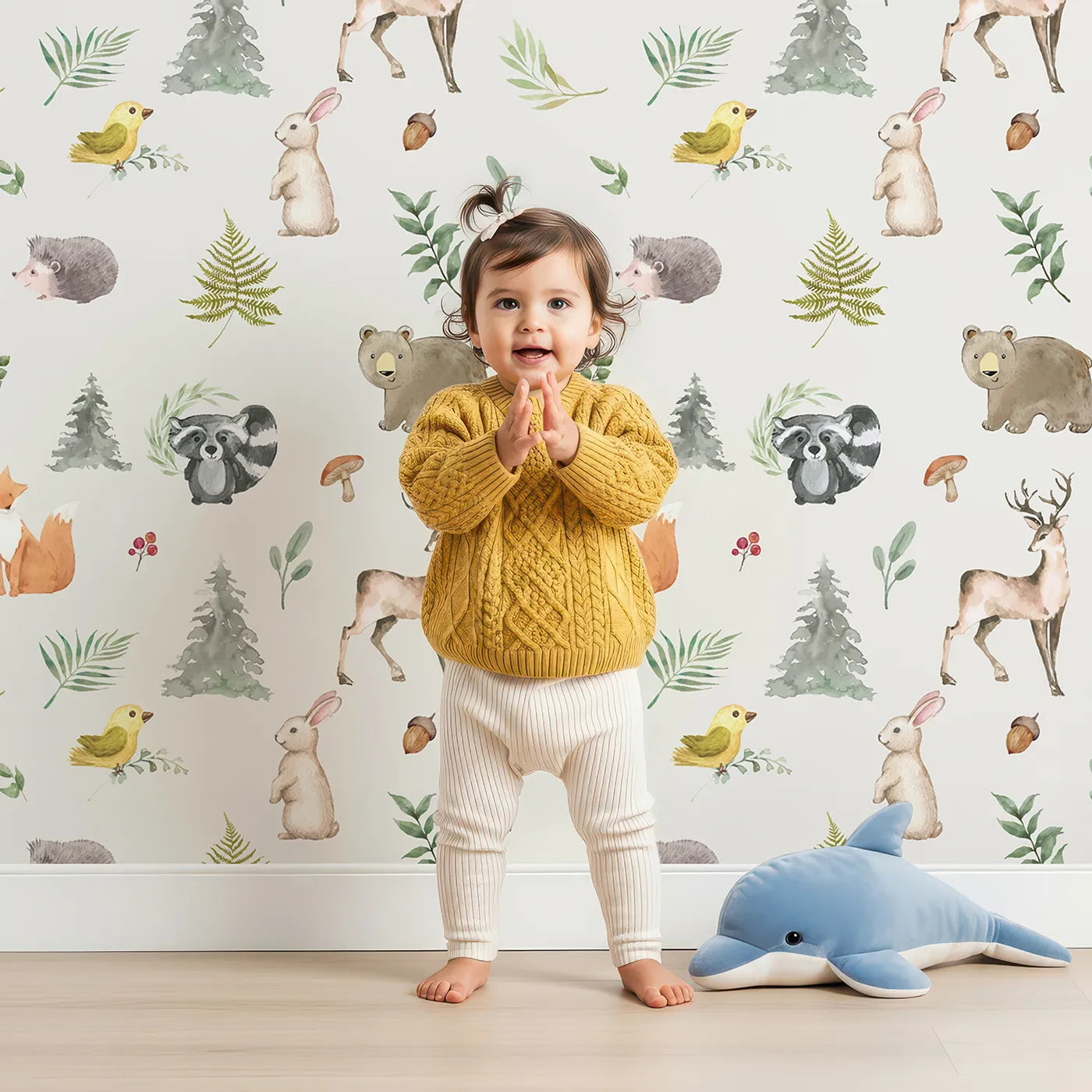 Lovely child standing in front of Whimsy Tots Watercolor Forest Friends Wallpaper with woodland, animal, watercolor, forest, fox in design.