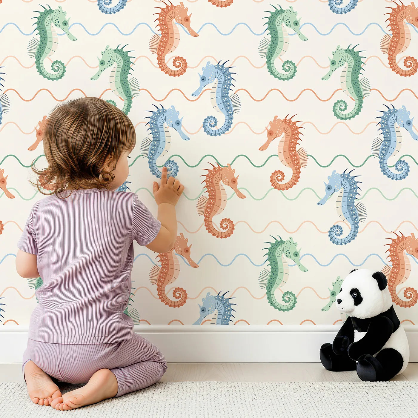 Lovely child standing in front of Whimsy Tots Wavy Seahorse Friends Wallpaper with seahorse, wave, ocean, sea, colorful in design.