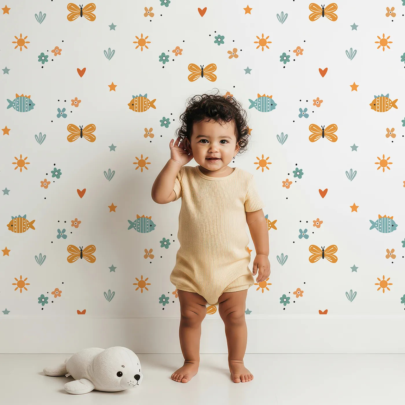 Lovely child standing in front of Whimsy Tots Whimsical Meadow Friends Wallpaper with doodle, fish, butterfly, flower, star in design.