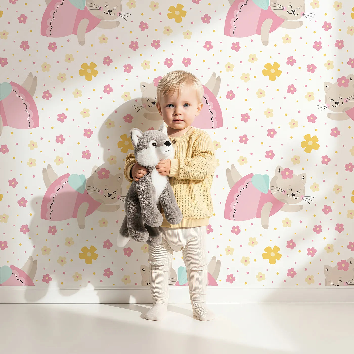 Lovely child standing in front of Whimsy Tots Ballerina Cat Garden Wallpaper in White with cat, ballerina, flower, dance, cute in design.