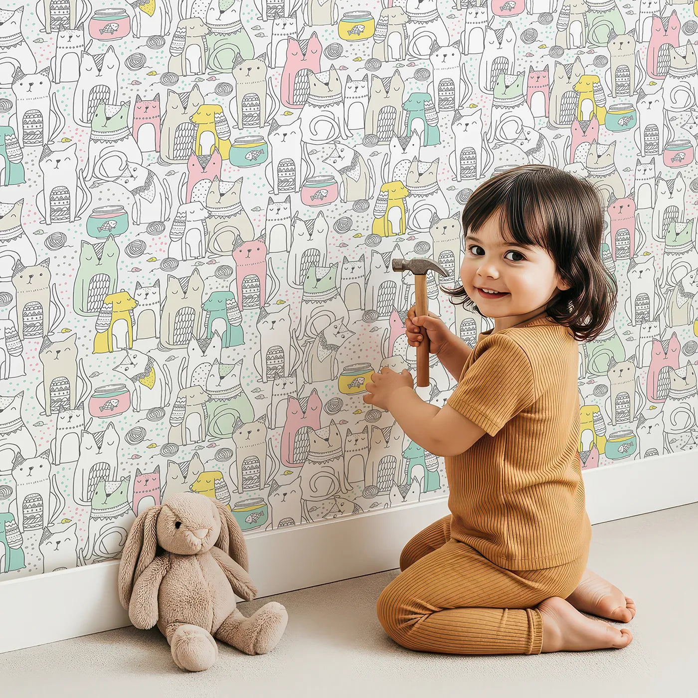 Lovely child standing in front of Whimsy Tots Pastel Cat Party Wallpaper with cat, doodle, pastel, cute, artistic in design.