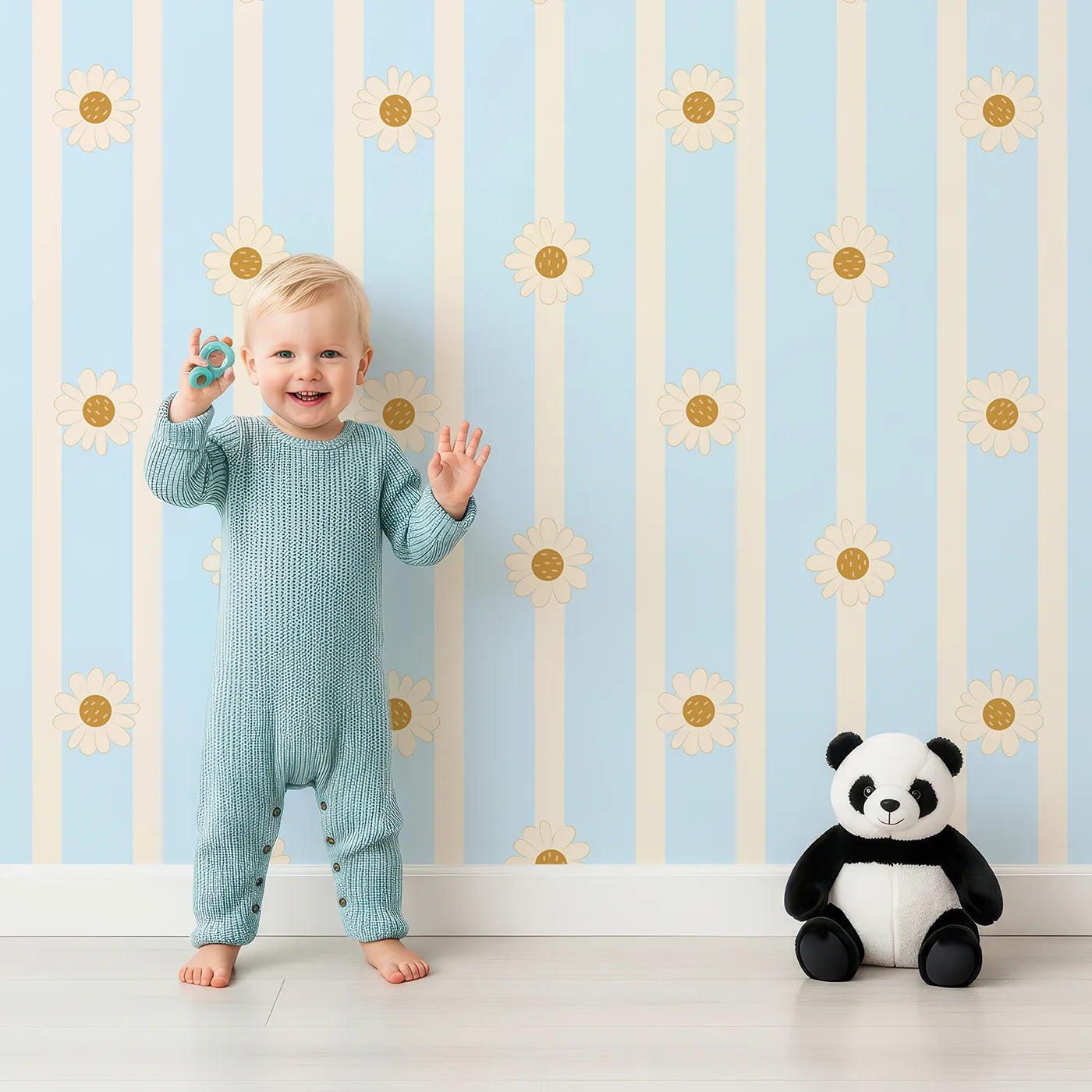 Lovely child standing in front of Whimsy Tots Daisy Lane Stripe Wallpaper in Blue with daisy, flower, stripe in design.