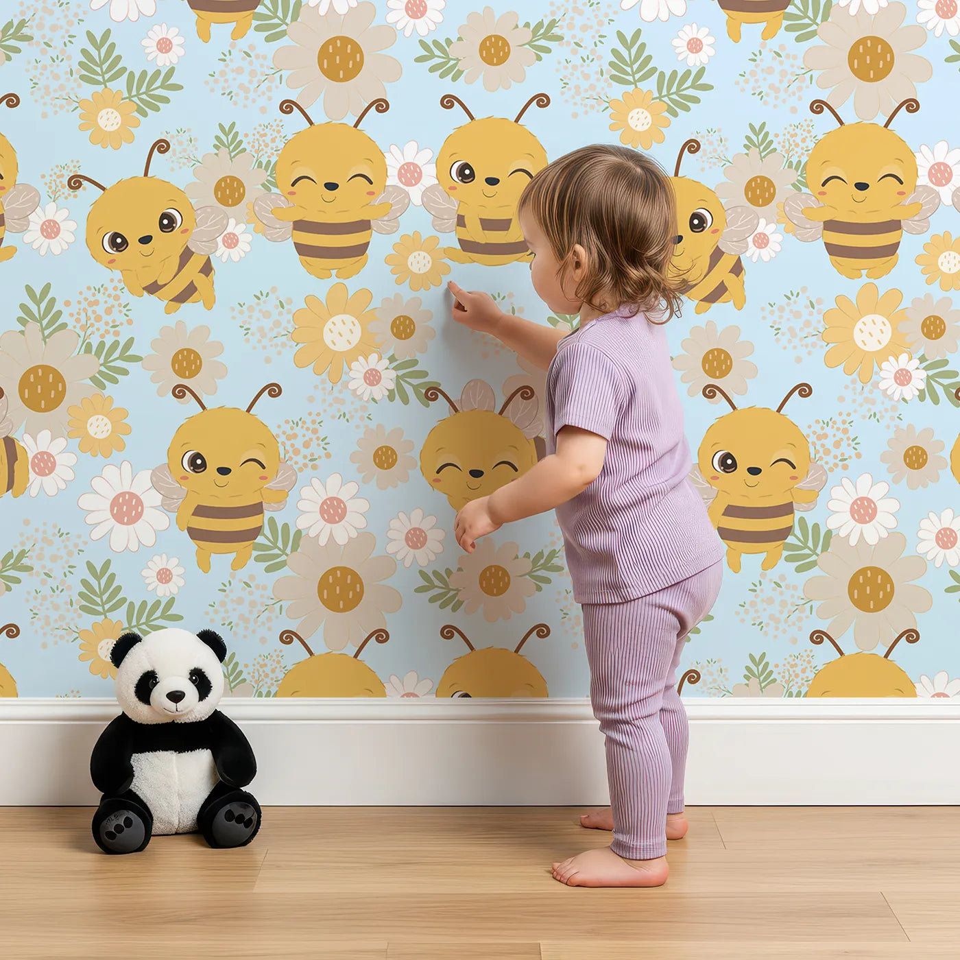 Lovely child standing in front of Whimsy Tots Bee Garden Blooms Wallpaper in Blue with bee, flower, daisy, leaf in design.