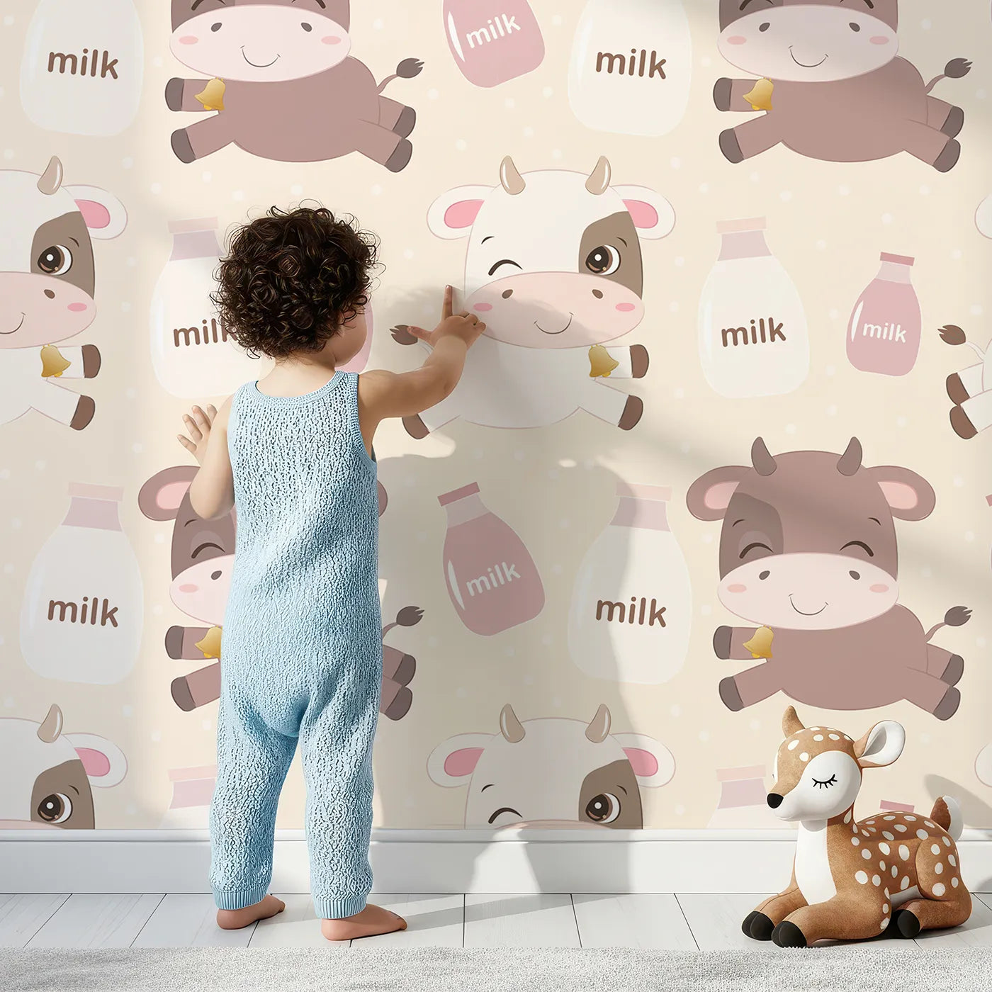 Lovely child standing in front of Whimsy Tots Moo Moo Milk Parade Wallpaper in Cream with cow, bottle, bell, dot in design.
