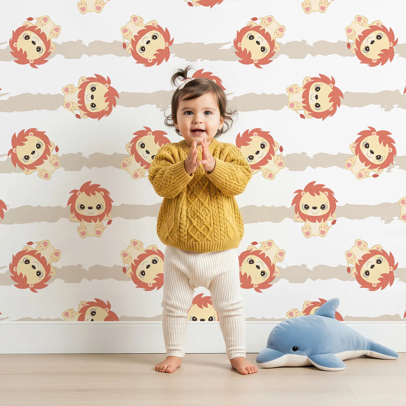 Lovely child standing in front of Whimsy Tots Striped Safari Cubs Wallpaper in Beige with lion, stripe, paw in design.