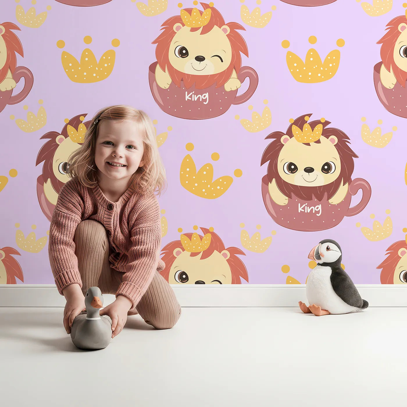 Lovely child standing in front of Whimsy Tots Little King of the Jungle Wallpaper in Purple with lion, crown, teacup in design.