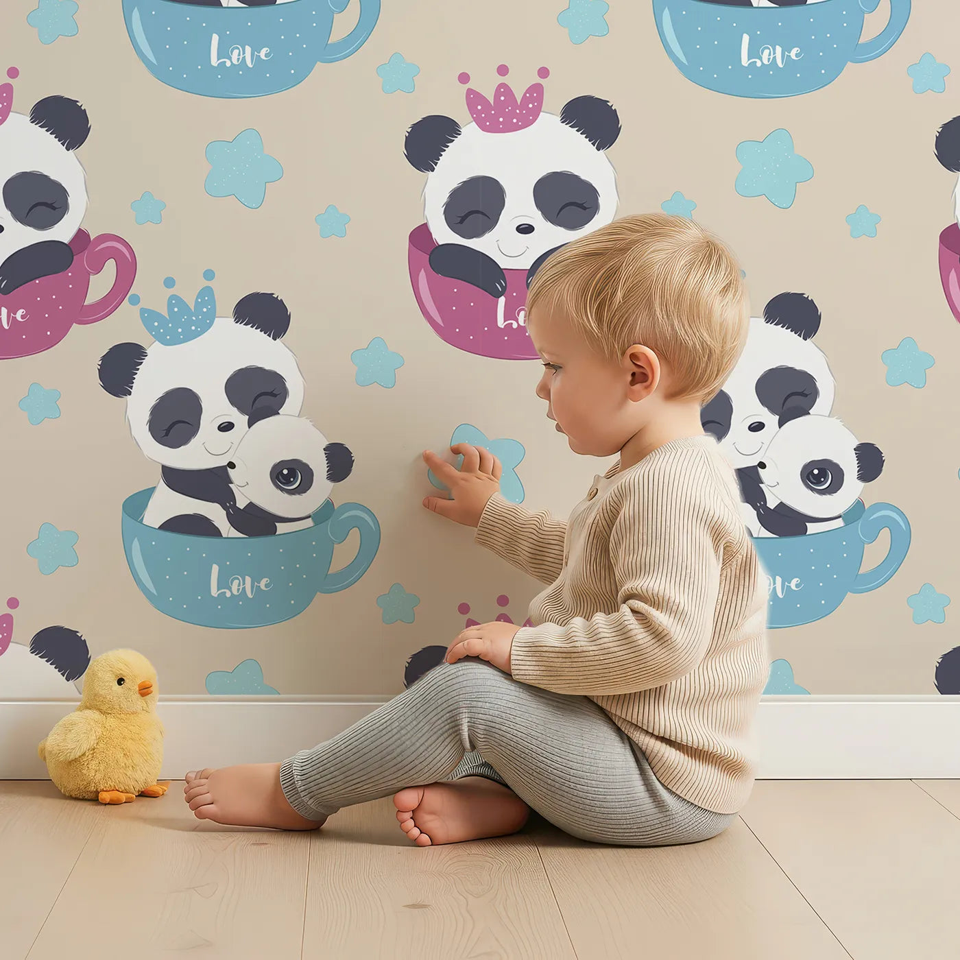 Lovely child standing in front of Whimsy Tots Cuddle Cup Panda Wallpaper in Beige with panda, cup, star, crown in design.