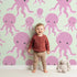 Lovely child standing in front of Whimsy Tots Ocean Bubbles Octopus Wallpaper in Mint Green with octopus, tentacle, dot, sea in design.