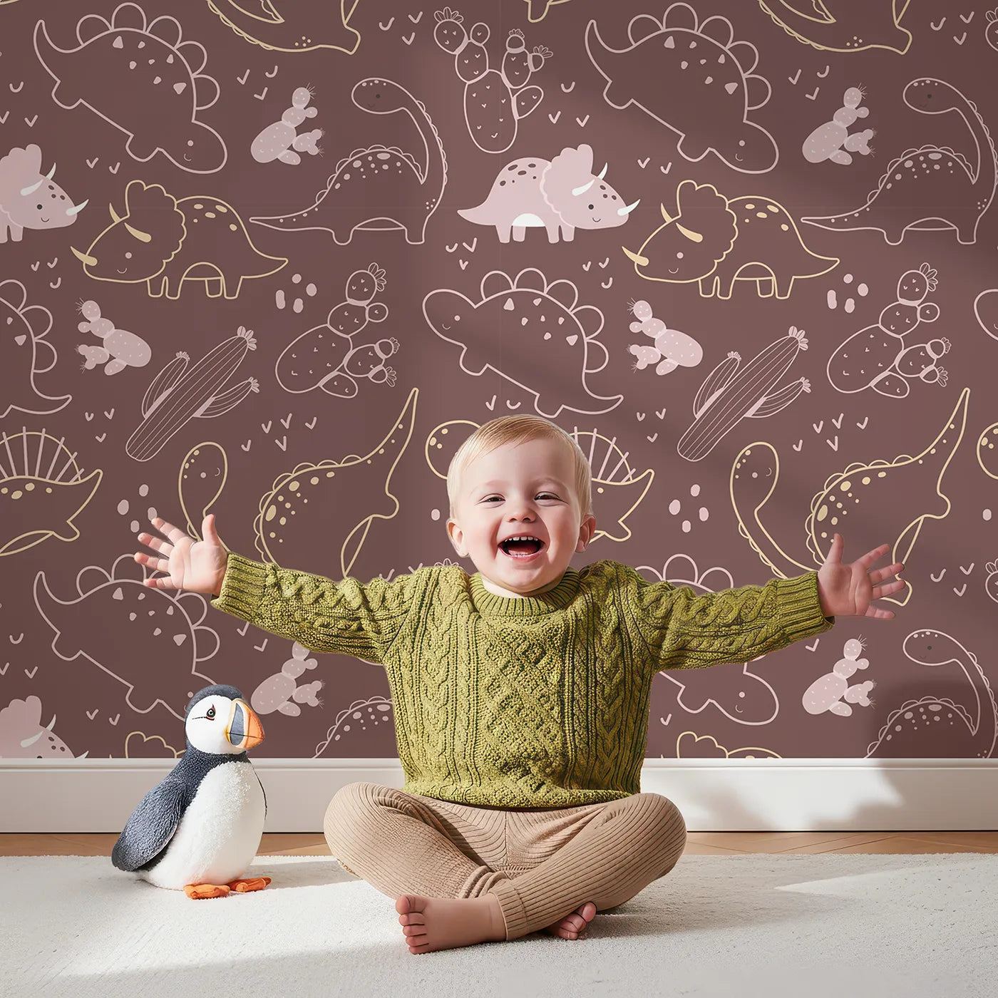 Lovely child standing in front of Whimsy Tots Midnight Dino Parade Wallpaper in Cocoa Brown with dinosaur, cactus, heart, footprint in design.