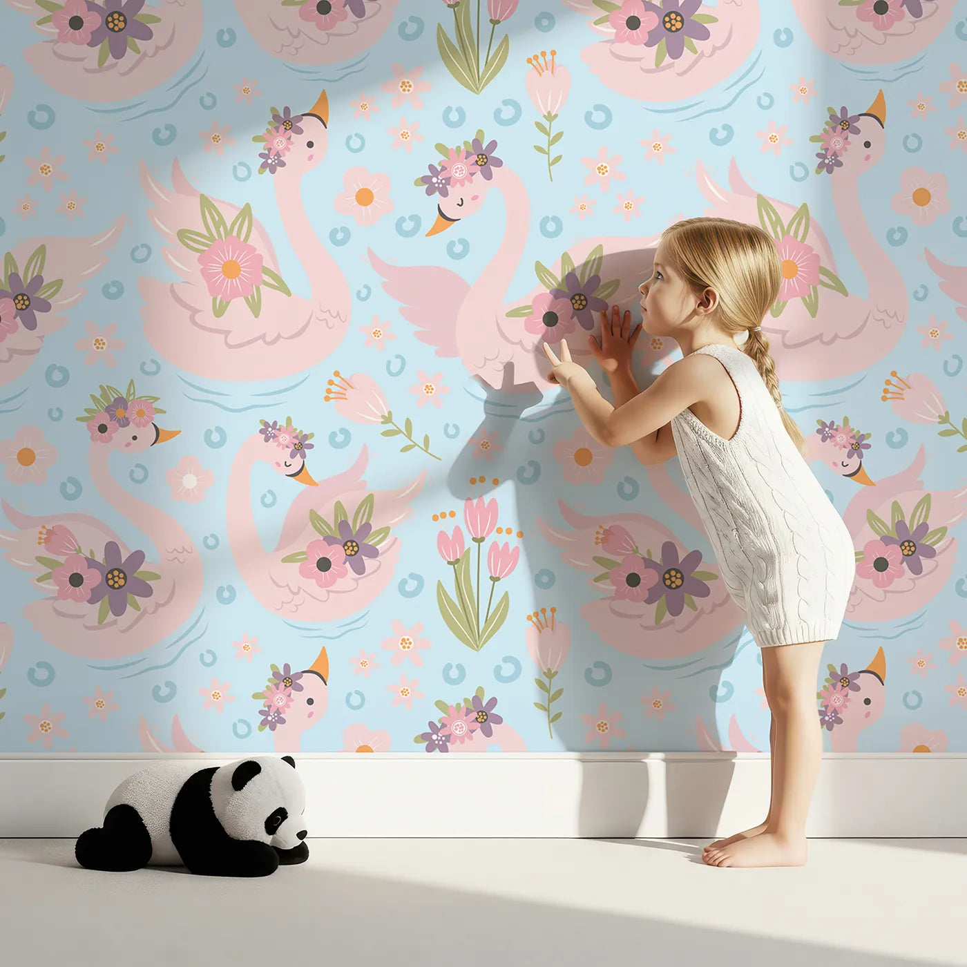 Lovely child standing in front of Whimsy Tots Blooming Swan Garden Wallpaper in Sky Blue with swan, flower, crown, tulip, ripple in design.