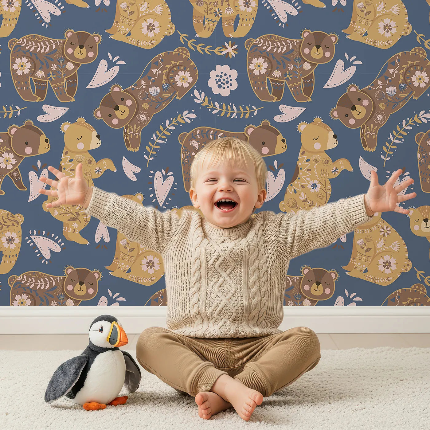 Lovely child standing in front of Whimsy Tots Floral Snuggle Bears Wallpaper in Denim Blue with bear, flower, heart, leaf in design.